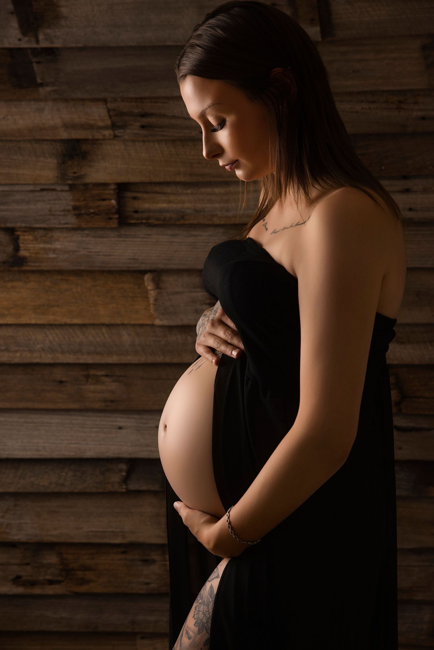 A series of silhouetted maternity photos showing a pregnant woman's belly against a rustic wooden wall background.
