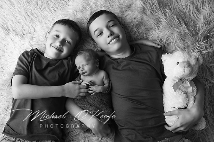A series of black and white intimate portraits showing tender moments between couples lying down together.