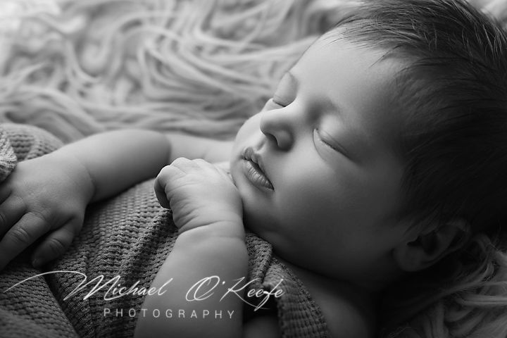 Black and white newborn photography of a sleeping baby by Michael O'Keefe Photography.