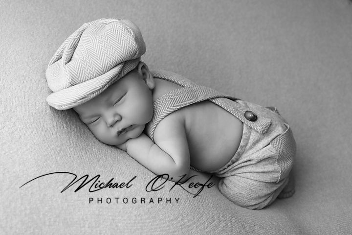 A collage of black and white newborn baby photography showing sleeping infants in artistic poses and soft lighting.