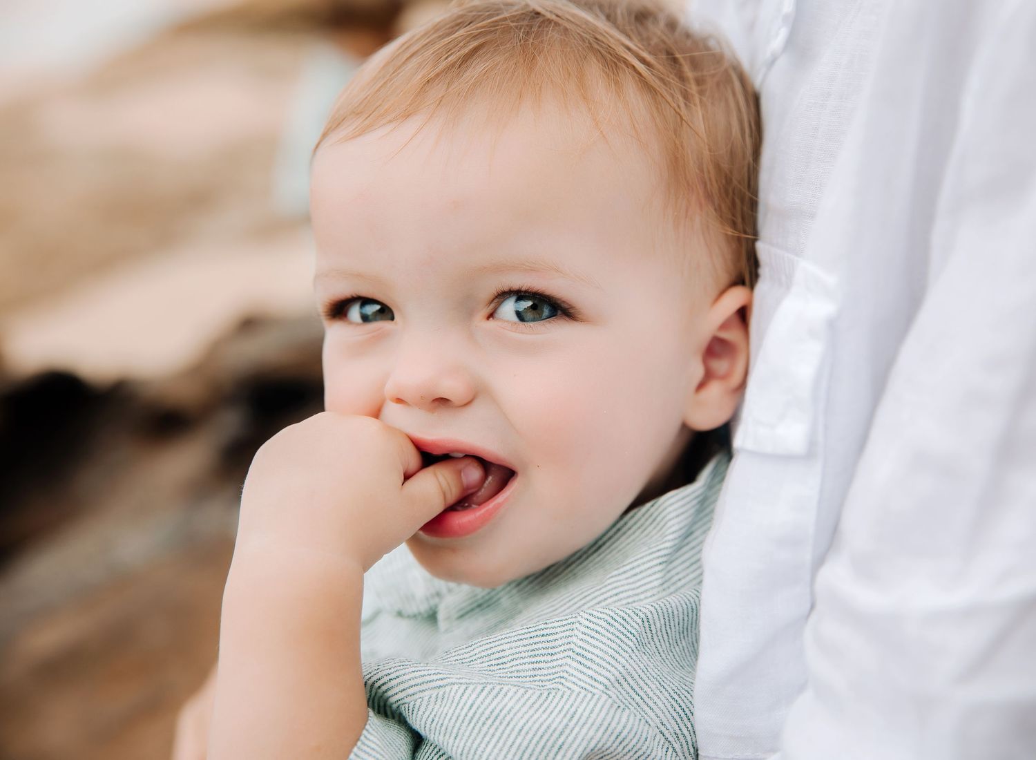 A collage of six close-up photos showing a baby with light hair making playful facial expressions and gestures.
