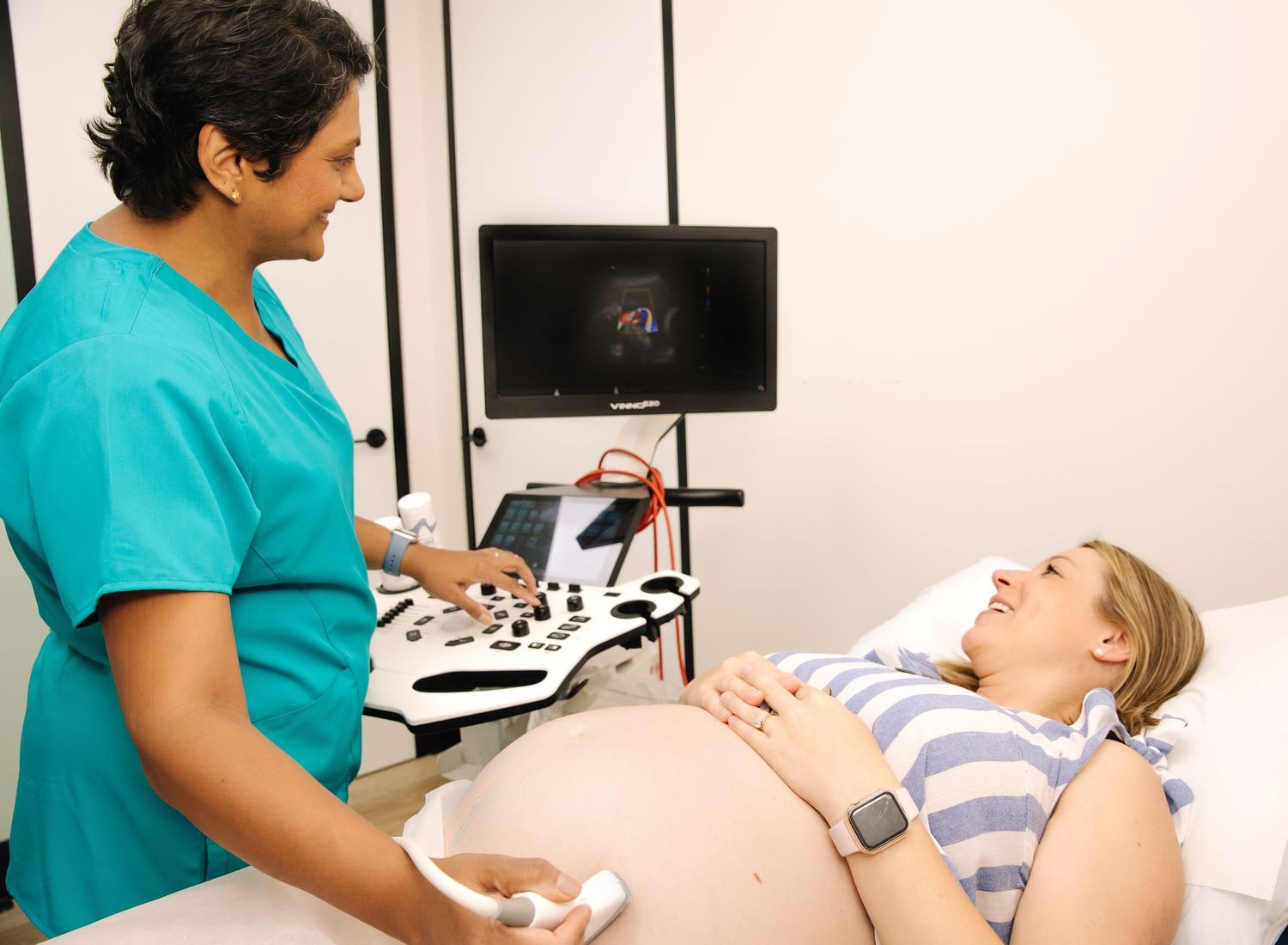 Medical professional provides neck ultrasound examination to patient lying on medical table in healthcare facility.