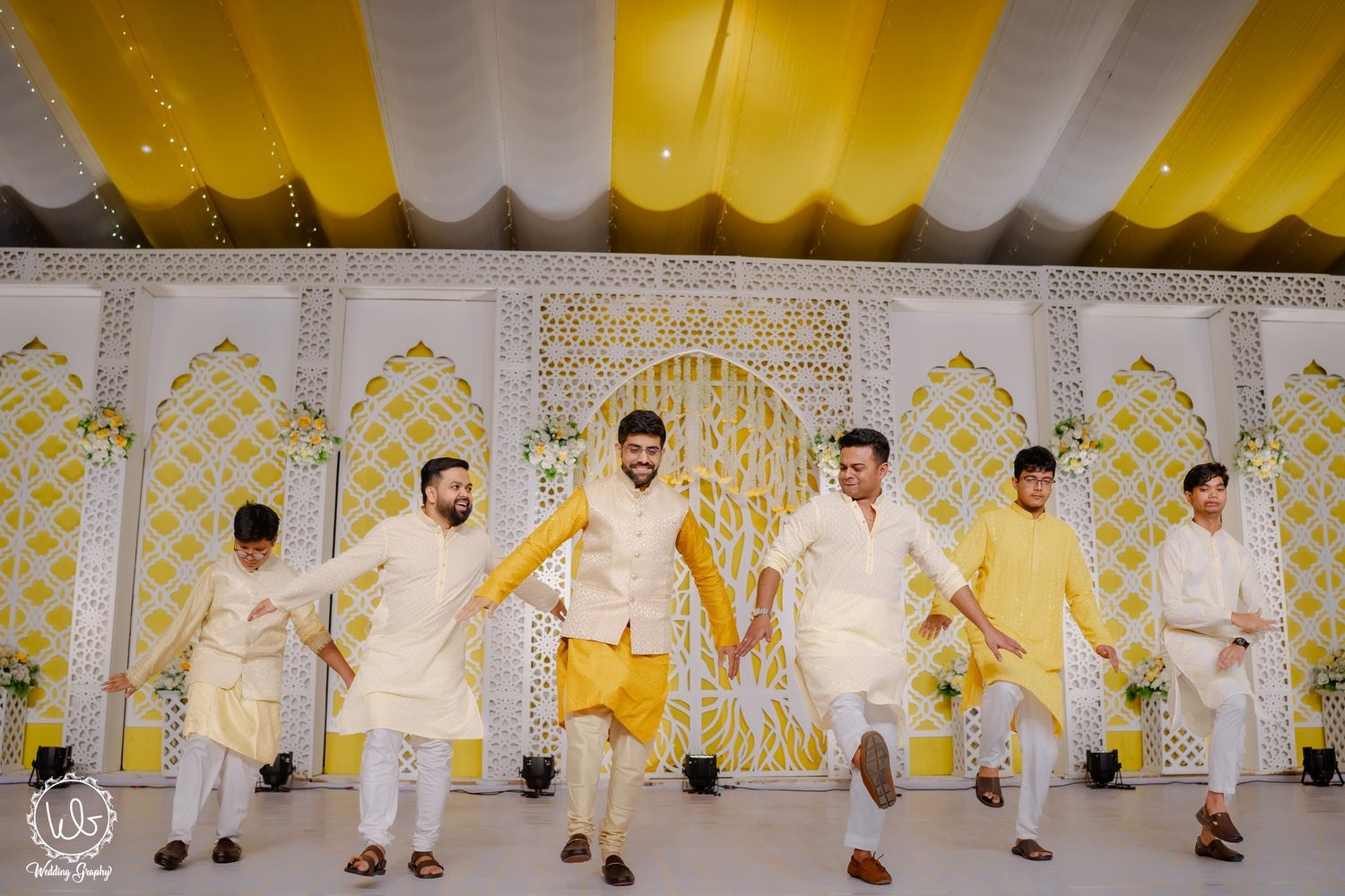 Elegant wedding reception venue decorated with yellow and white decor and floral arrangements.