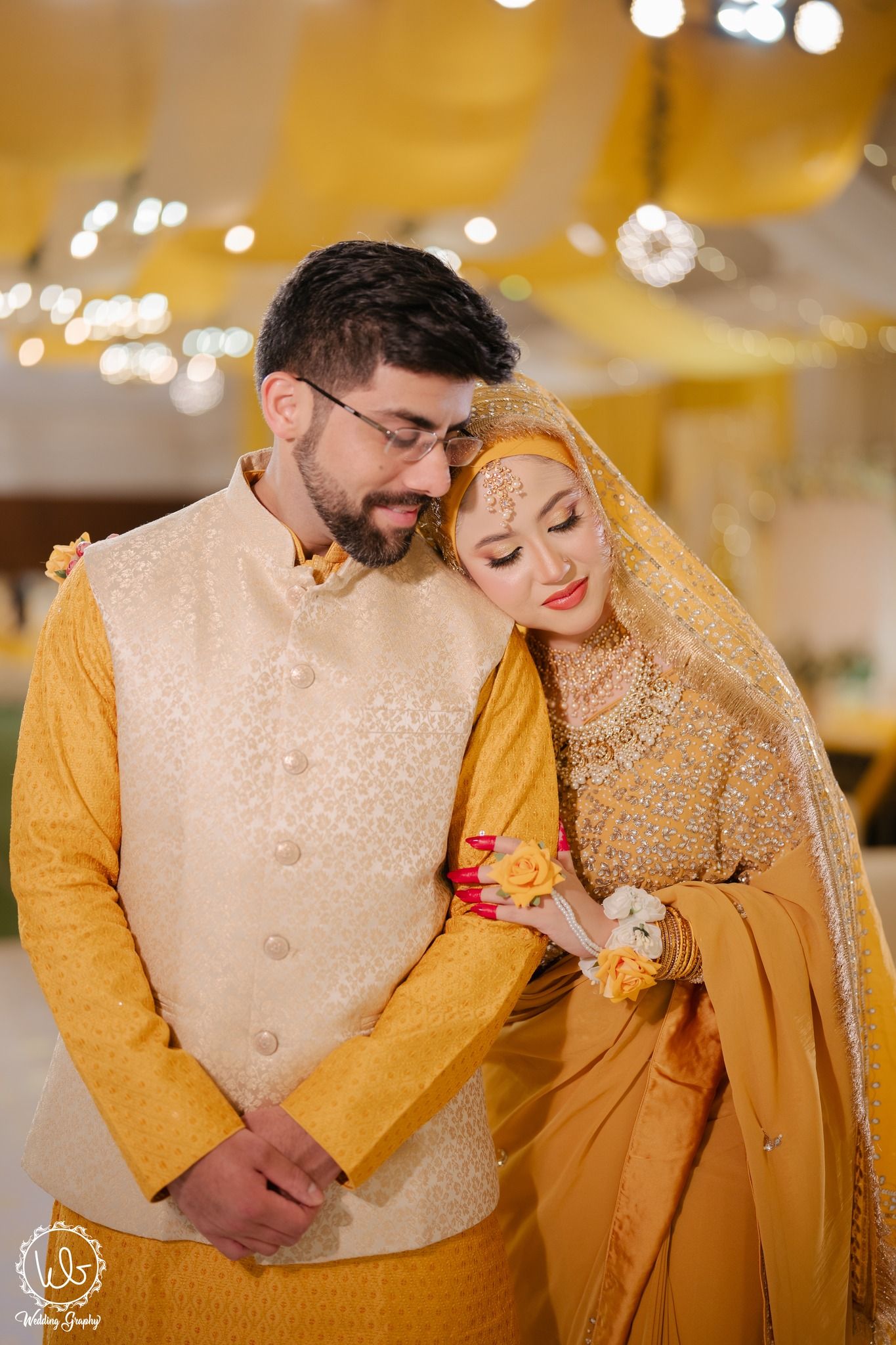 Romantic couple in matching yellow traditional outfits share intimate moments during a wedding celebration.