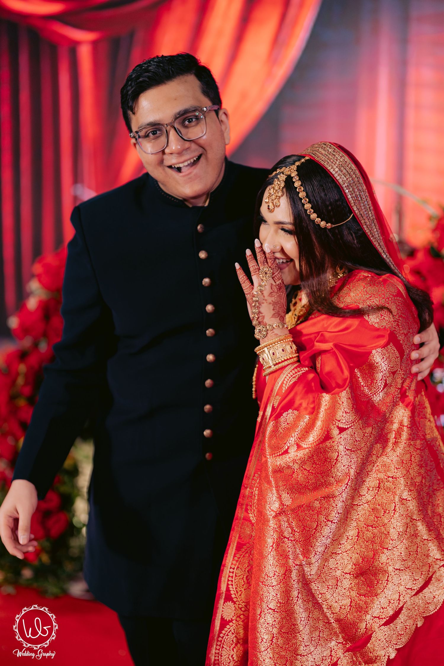 Traditional wedding couple in red and black attire during their celebration.