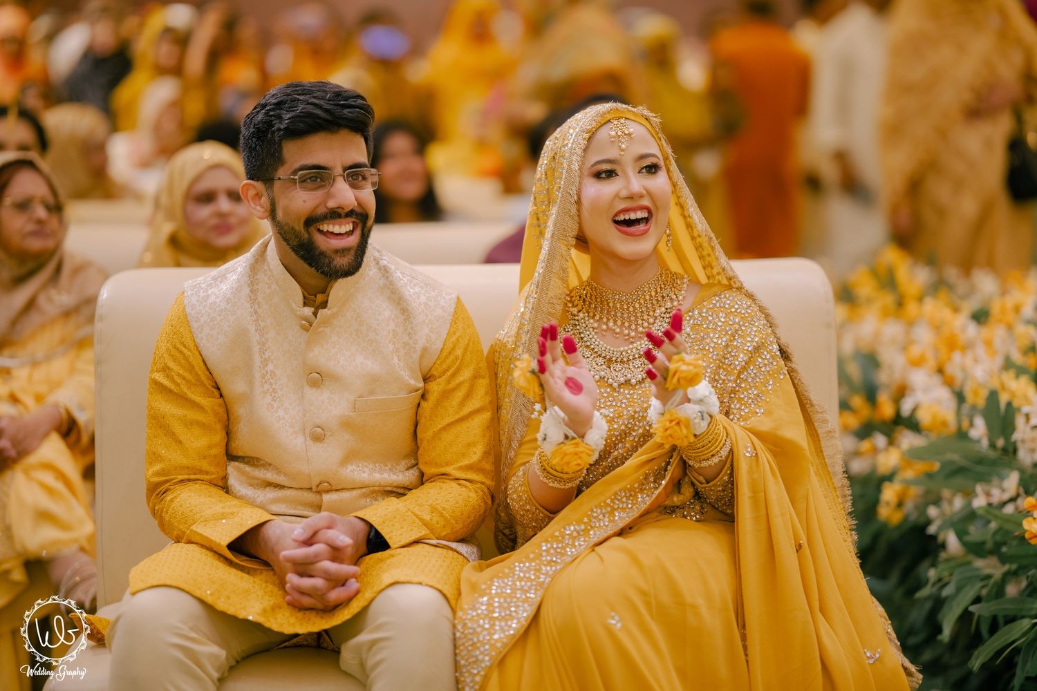 Wedding guests in vibrant yellow traditional attire share joyful moments during a celebration.