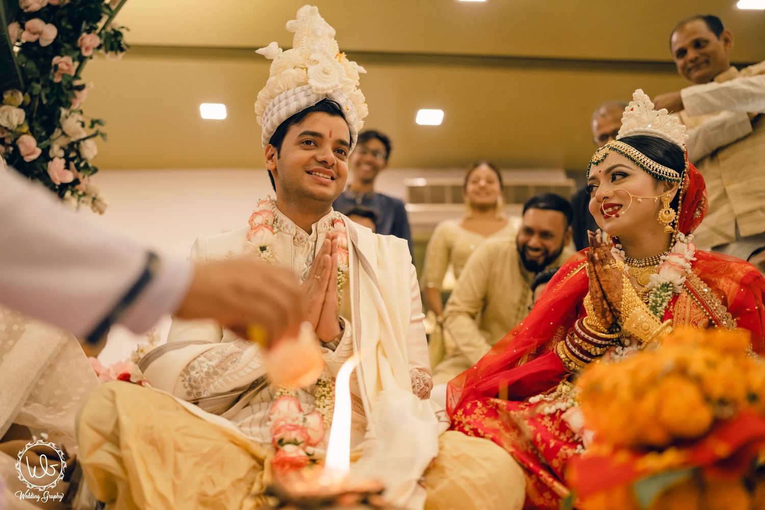 Wedding celebration scene with guests and decorations in an indoor venue.