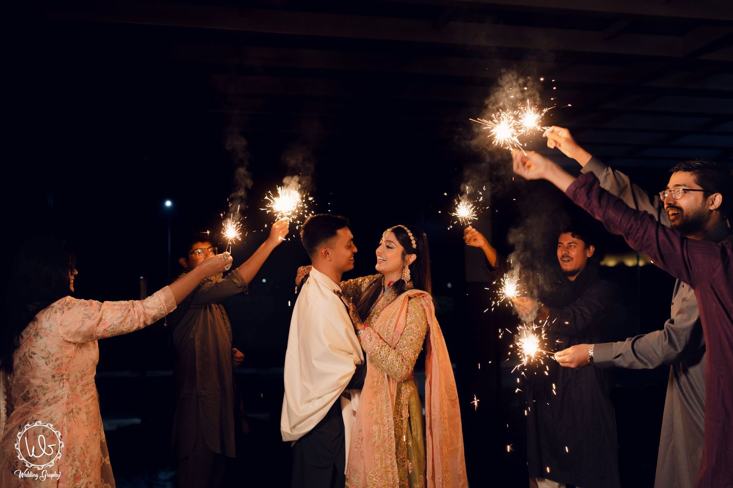 Wedding guests celebrate with sparklers during an evening celebration.