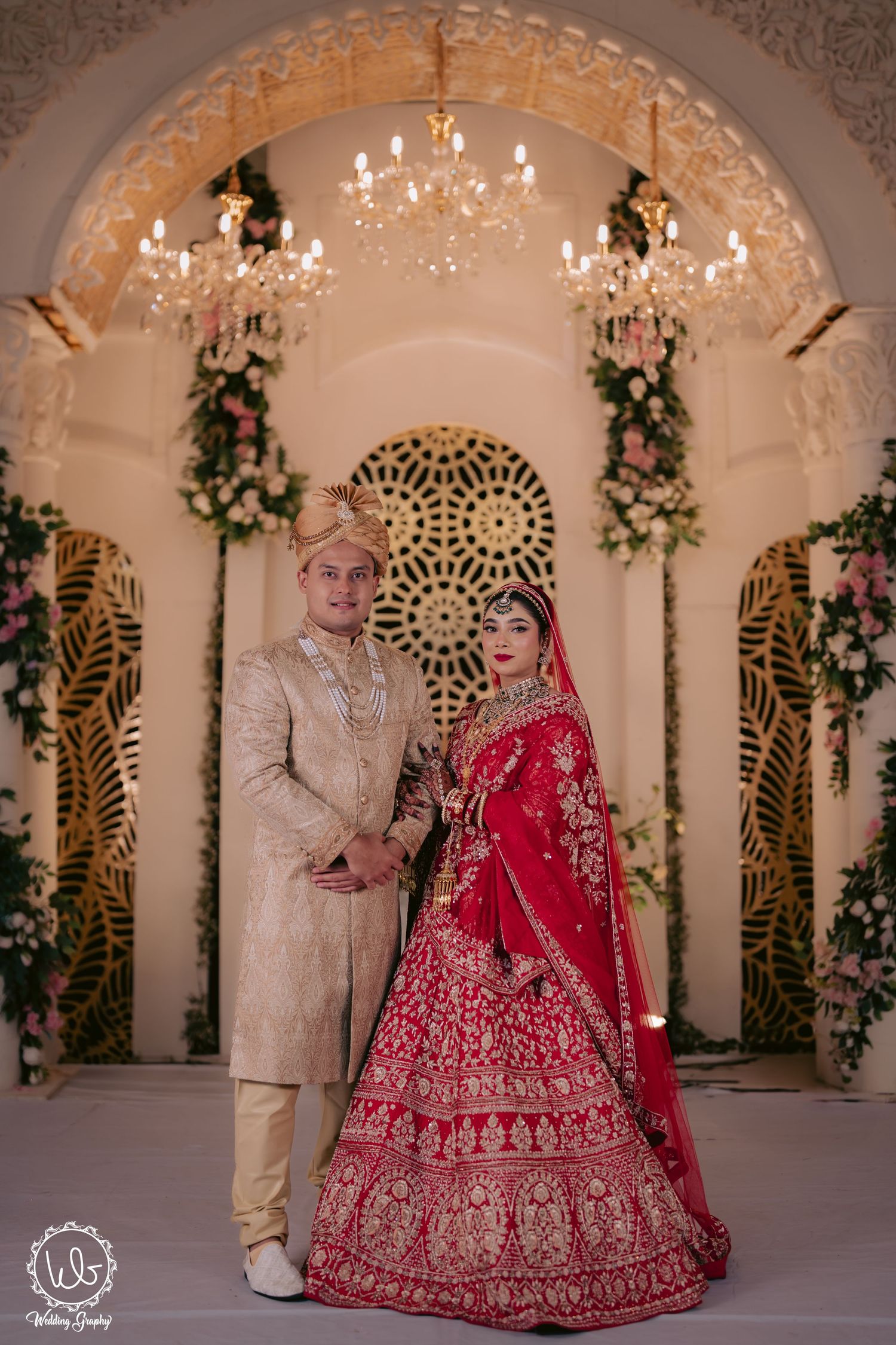 Wedding photoshoot in an elegant venue with arched architecture and crystal chandeliers.