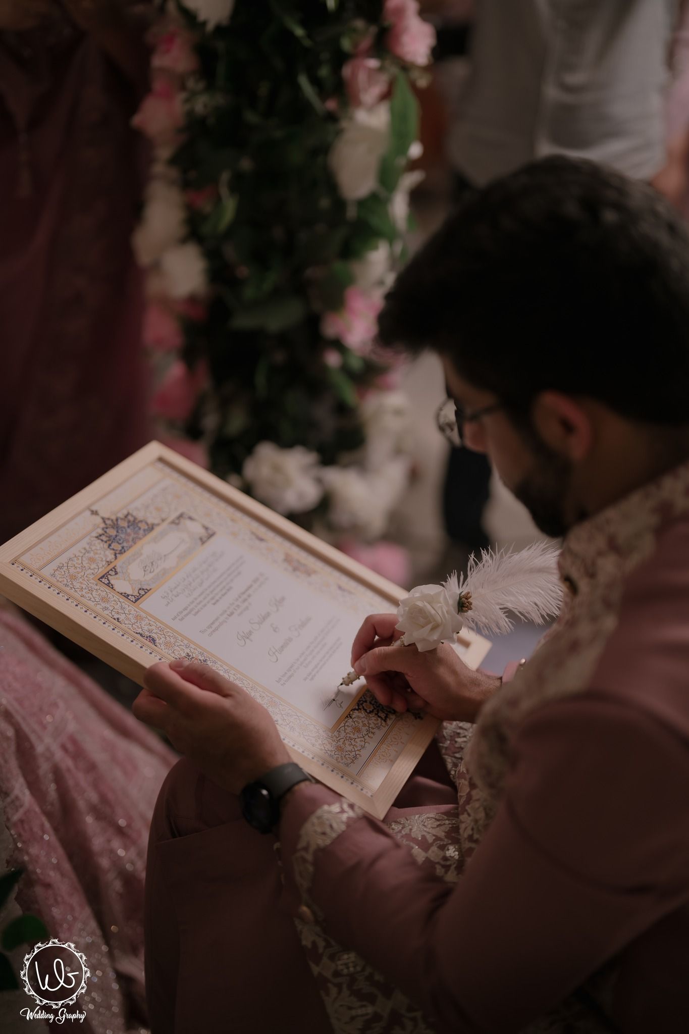 Close-up view of hands holding and reading from a traditional Islamic marriage contract during a wedding ceremony.