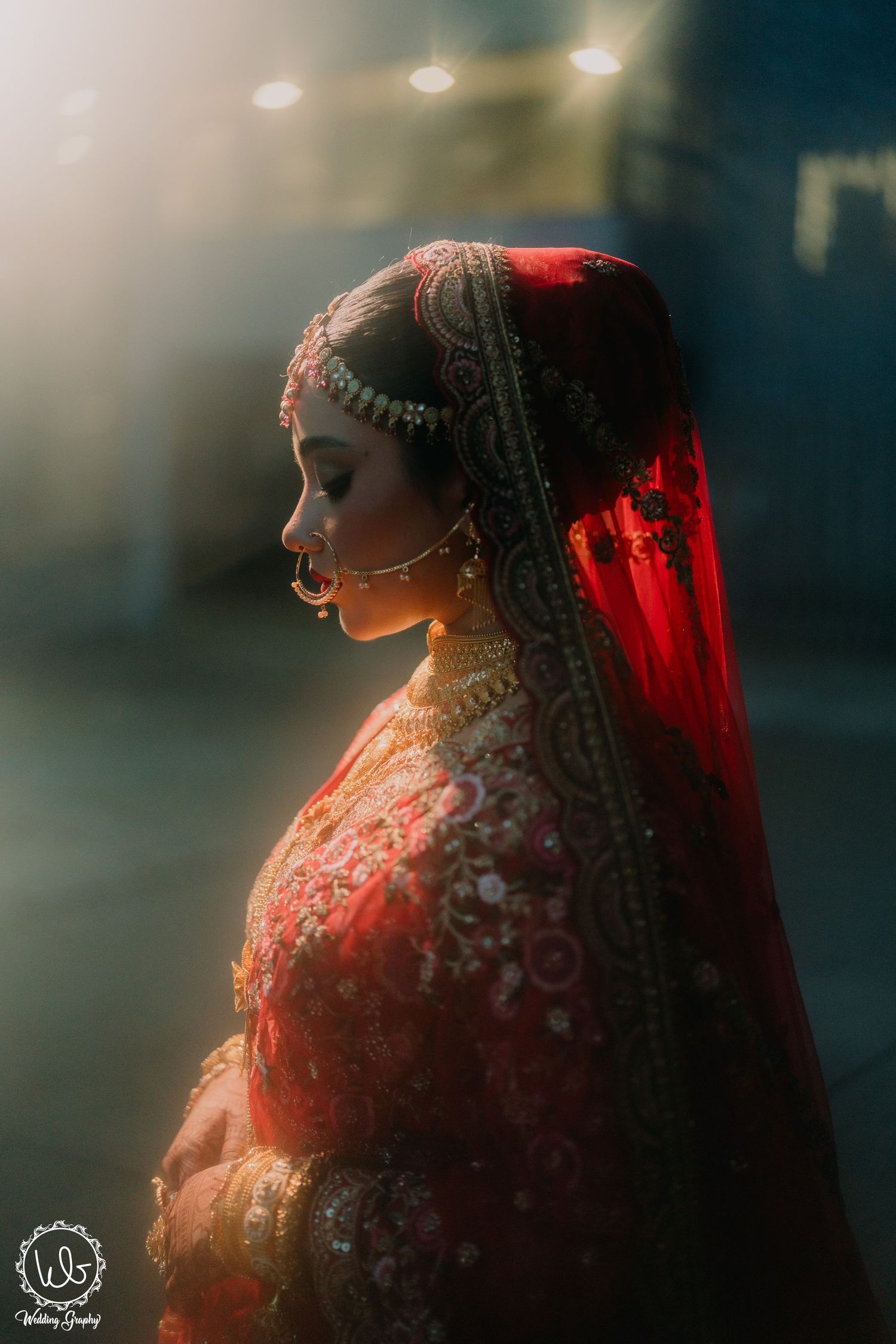 A traditional bride in red attire and henna designs illuminated by dramatic lighting in a series of profile shots.