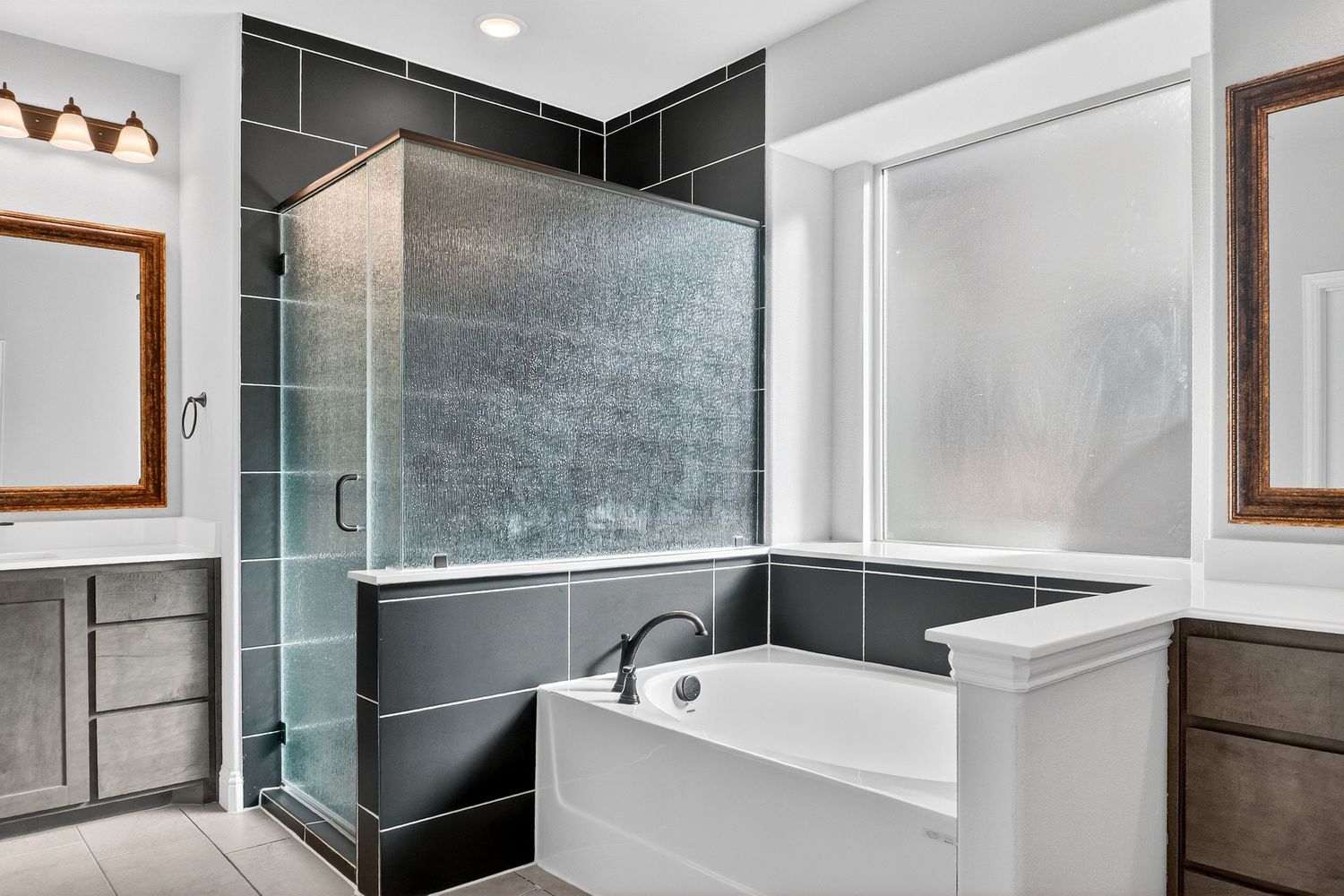 Contemporary bathroom featuring black tile walls, glass shower enclosure, and modern fixtures.