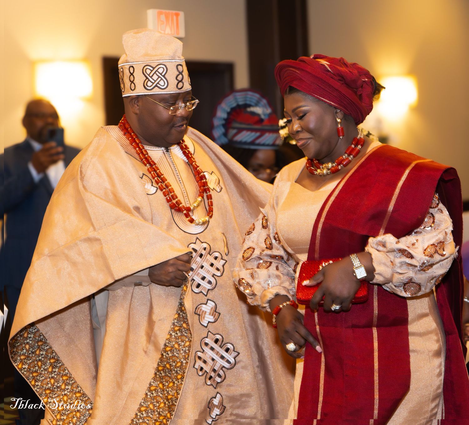 Traditional ceremony with participants wearing elegant white and red formal attire.