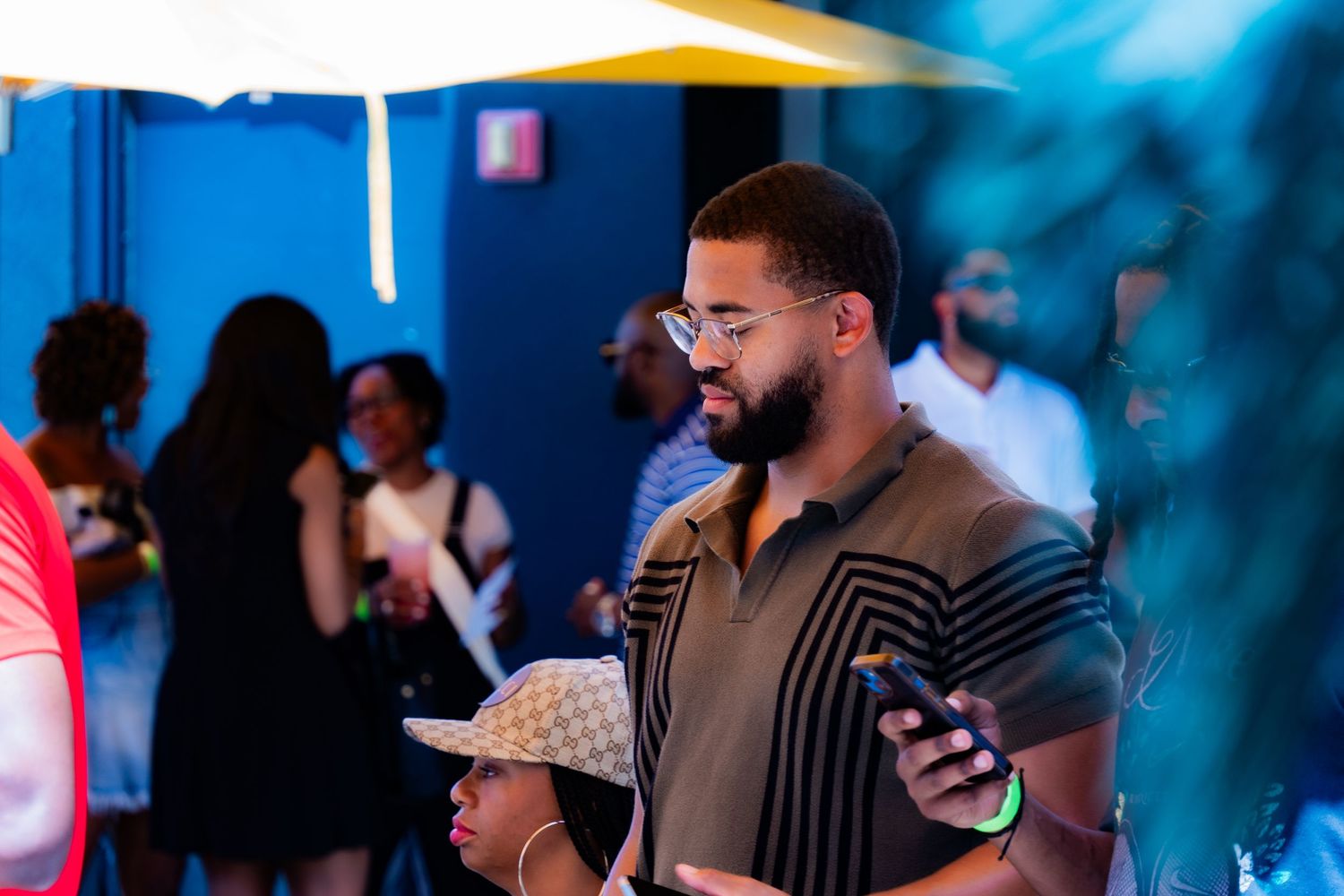 Person in a striped shirt checking their phone at an outdoor event.