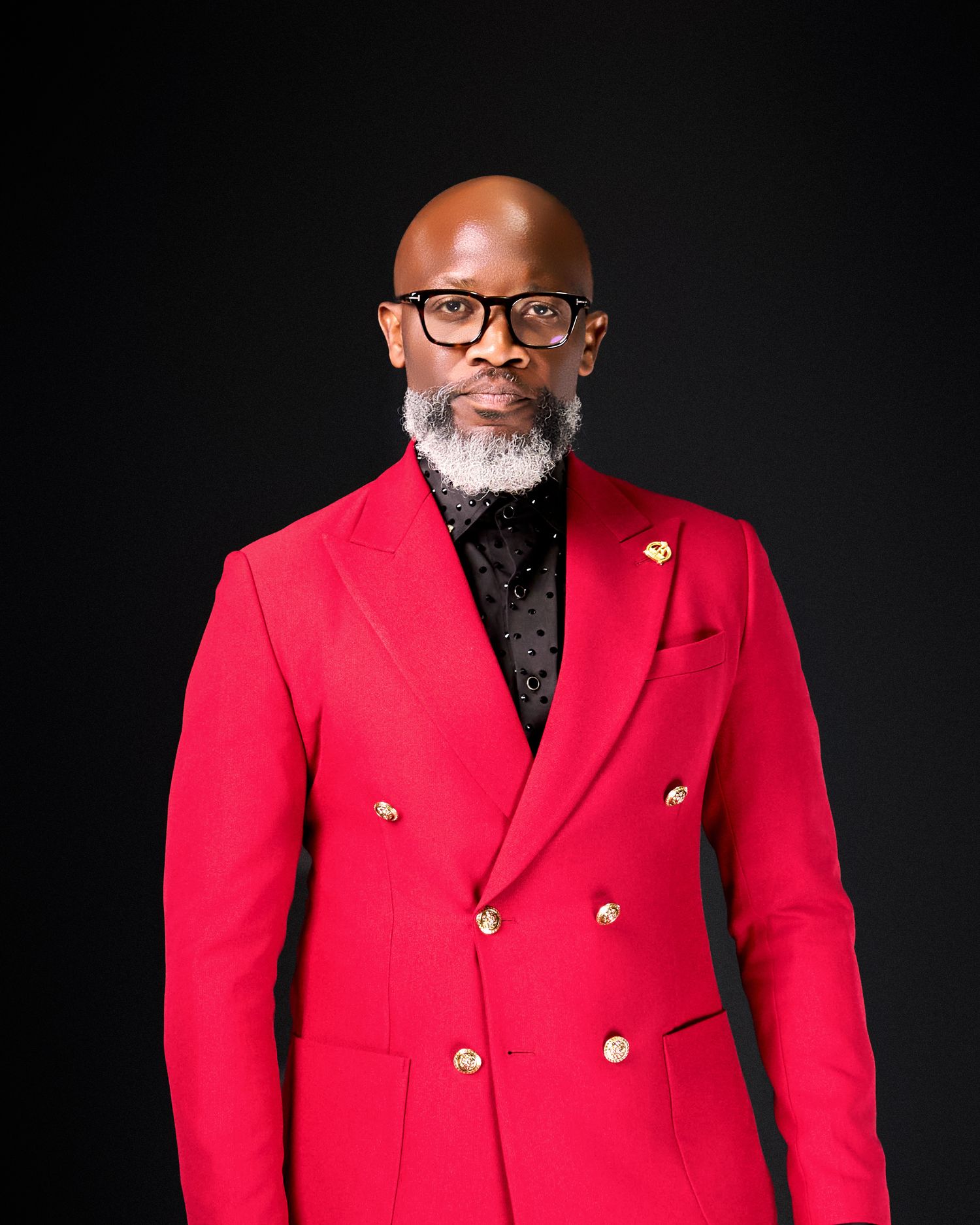 Bold red double-breasted blazer with gold buttons styled against dark background.