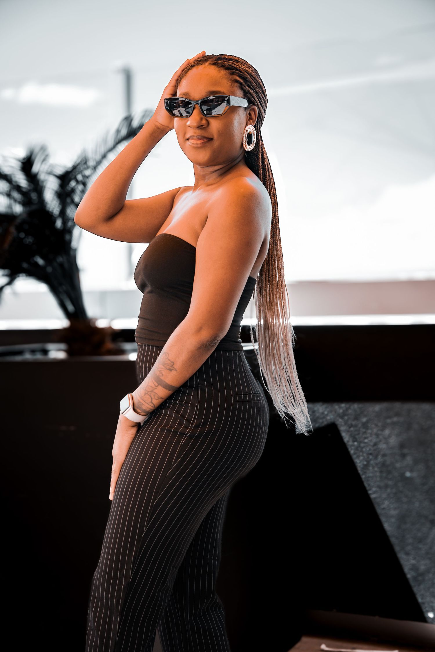 A fashion photo series showing a black ribbed dress against a bright background.