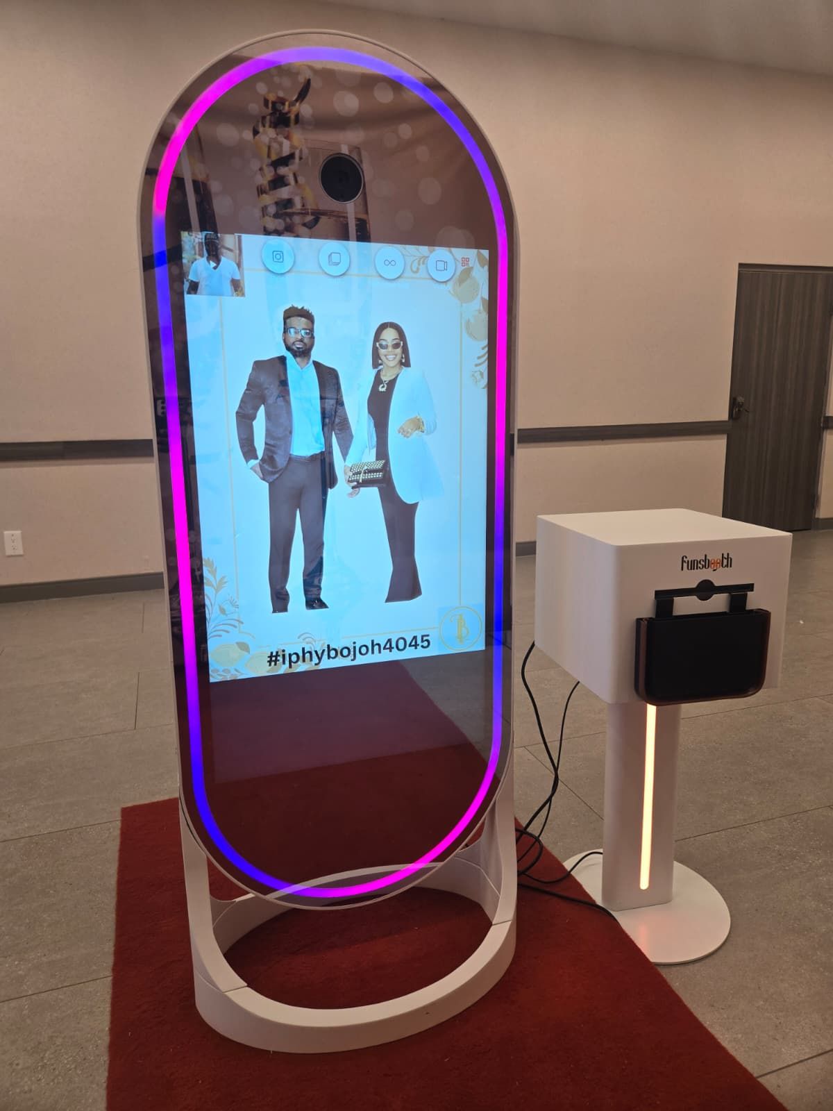 Interactive photo booth with illuminated arch frame displaying digital silhouettes.