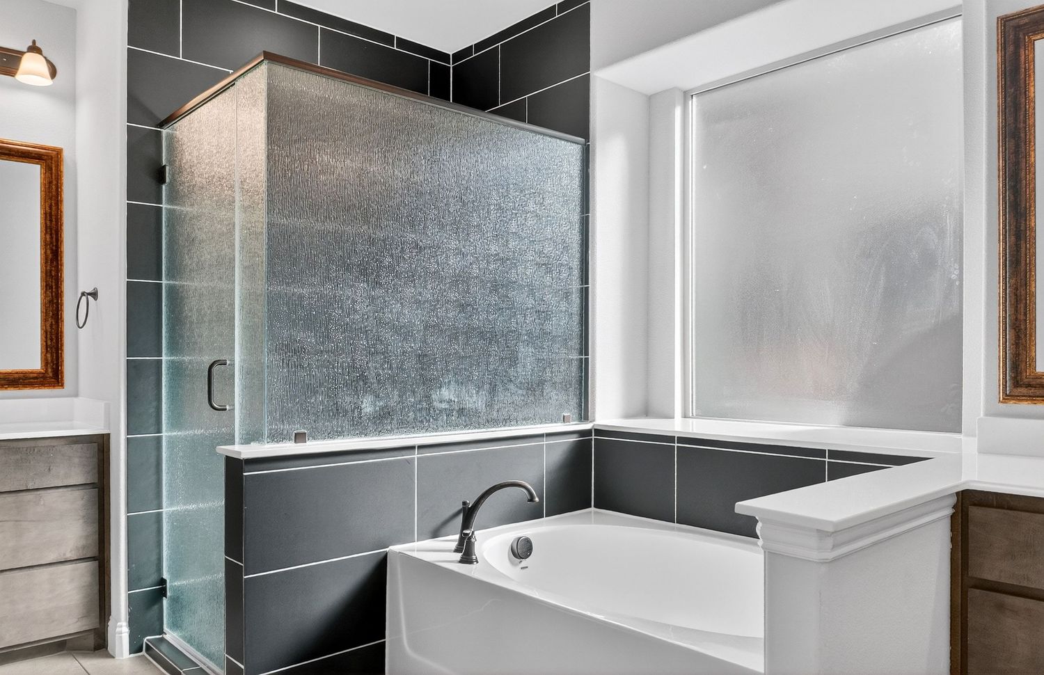 Modern bathroom featuring dark tile shower surround and glass door enclosure.