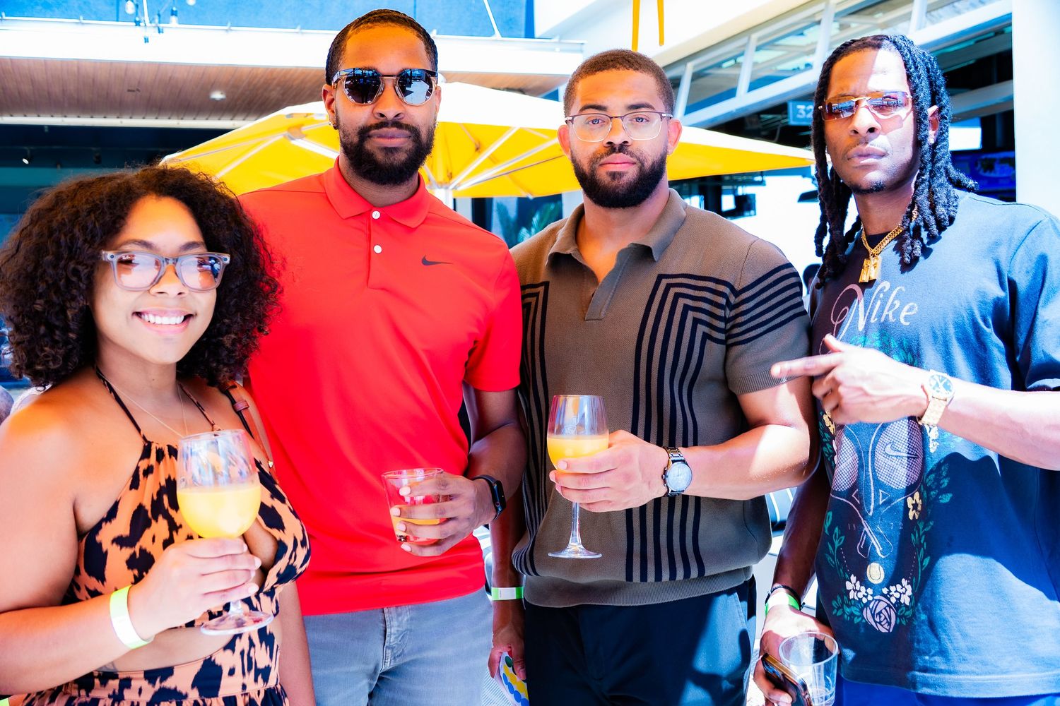 Group of friends posing with drinks at an outdoor social gathering.