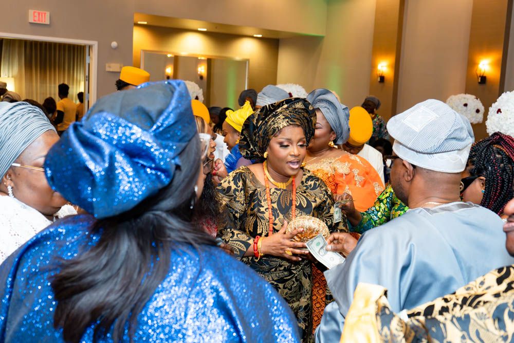 Wedding celebration with guests dancing and socializing in blue and gold traditional outfits.