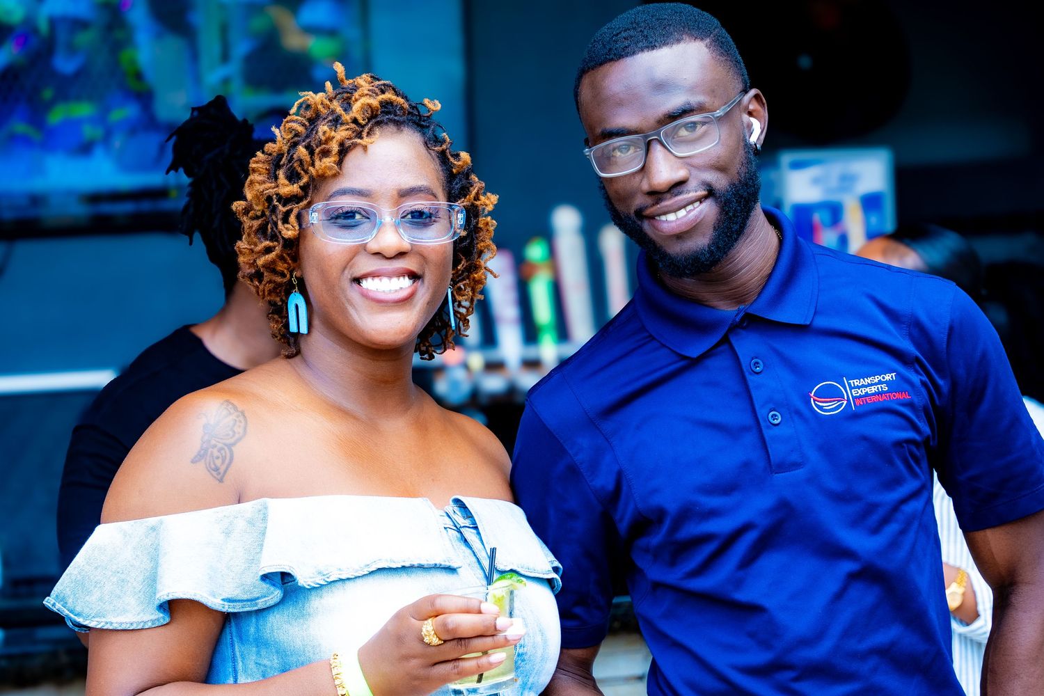 Couple smiling and enjoying drinks at an outdoor social event.