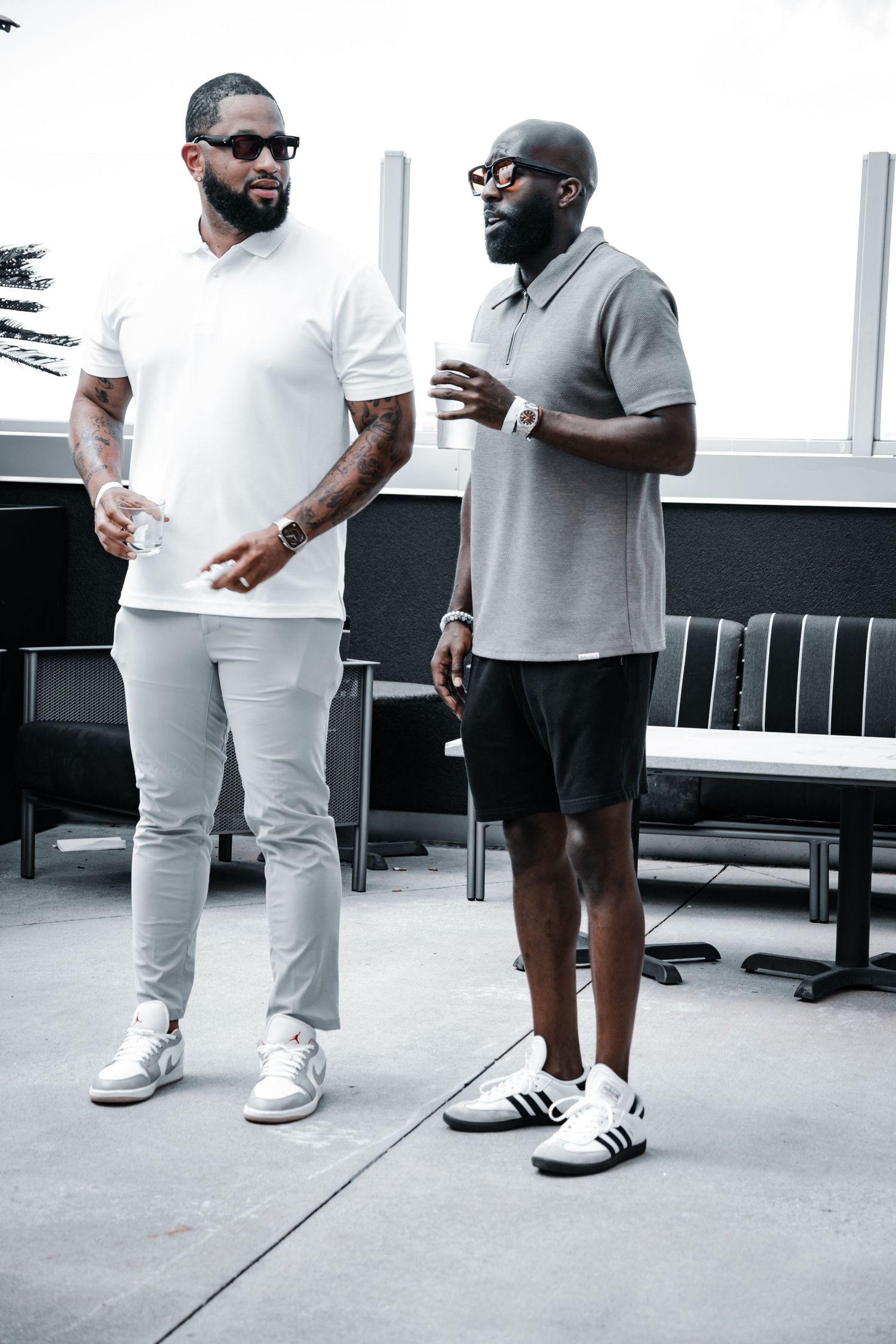Casual meetup scene with people in monochrome outfits and sneakers.