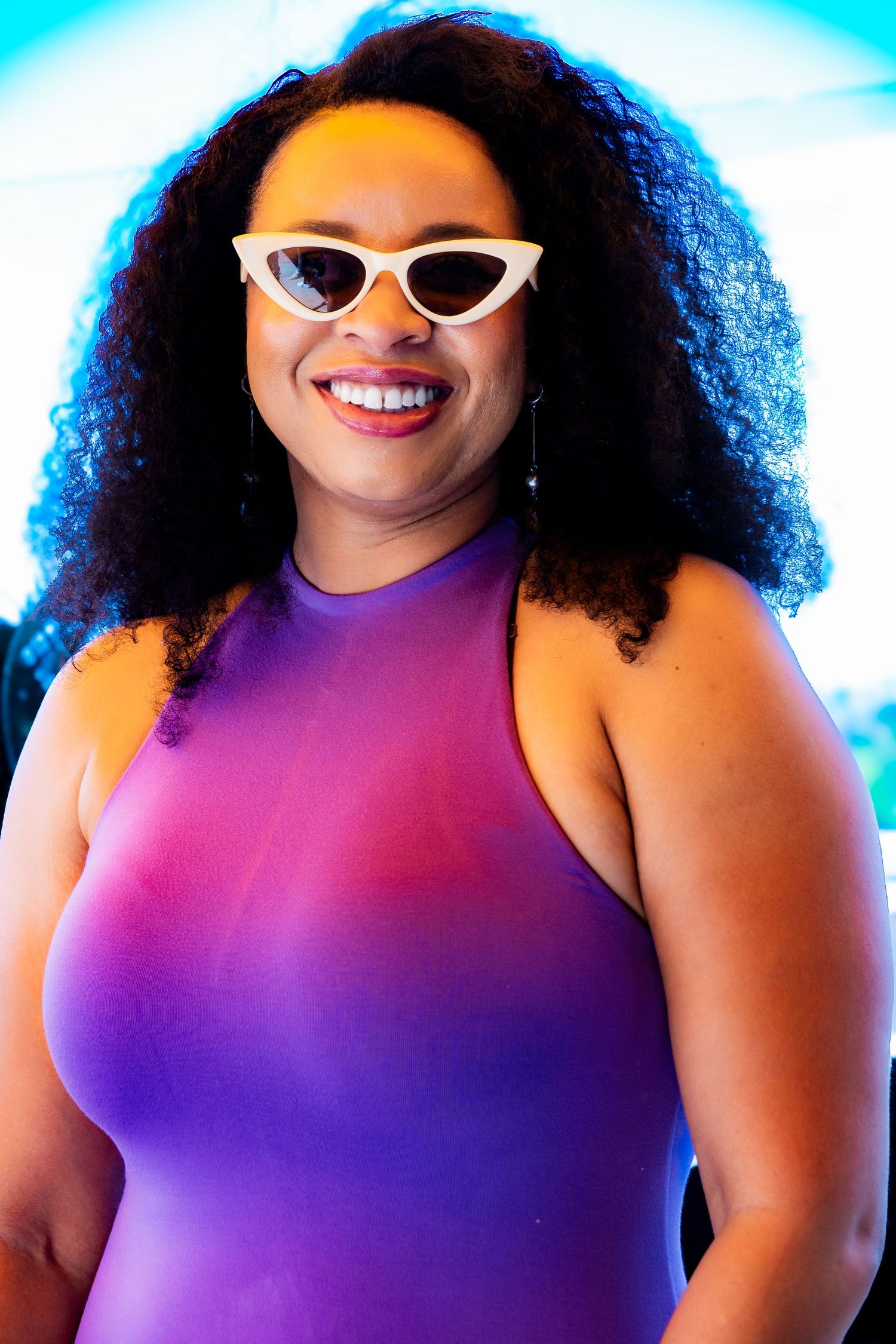 Vibrant gradient purple dress styled with retro white sunglasses in a summer photoshoot.