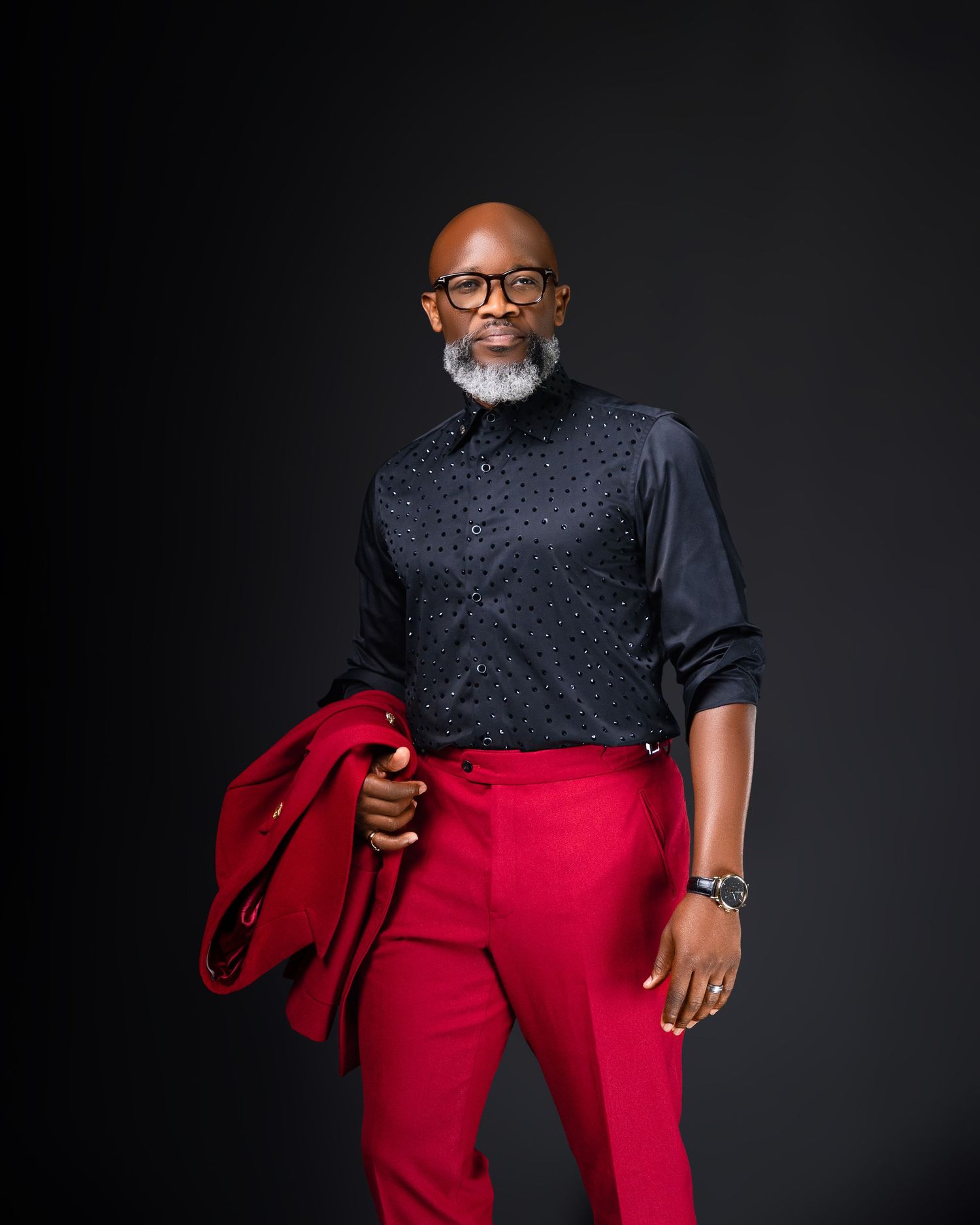 Fashionable outfit featuring sparkly black top and bright red pants in studio setting.