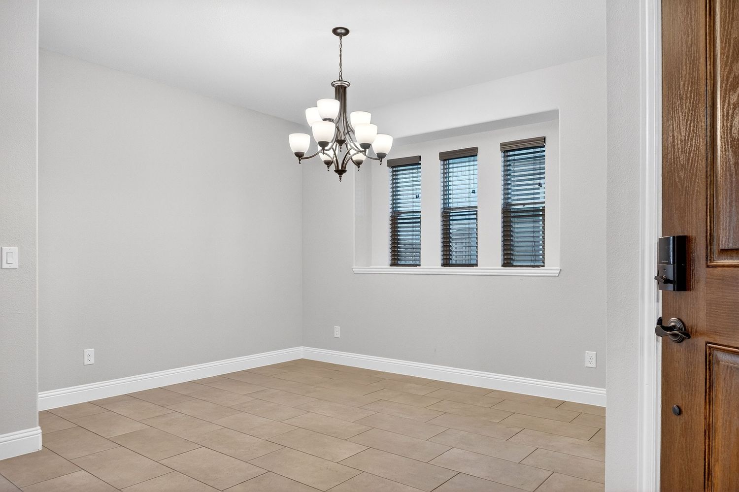 Modern interior room with chandelier and gray walls featuring an open concept design.