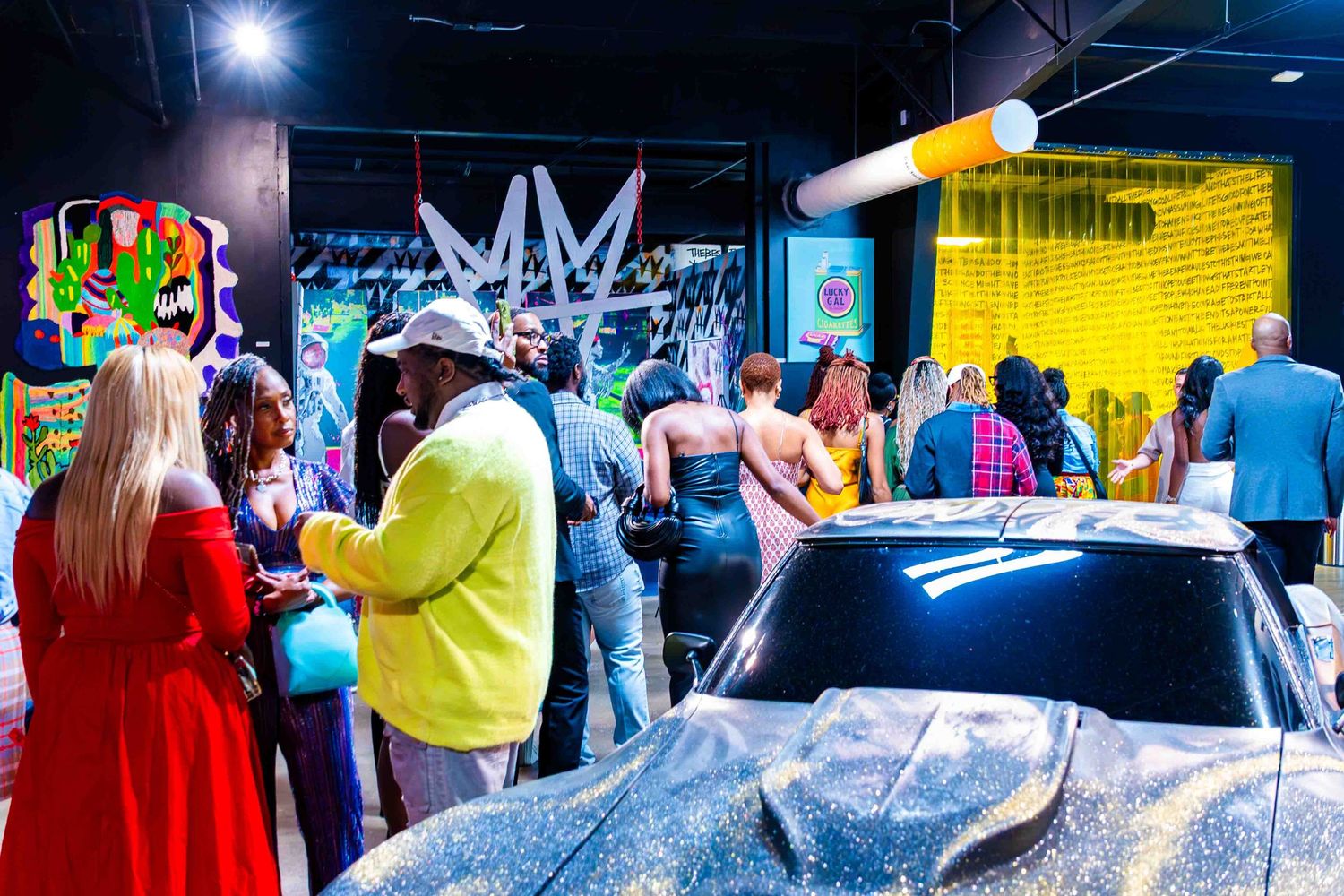 People walking through an indoor event space with bright lighting and displays.