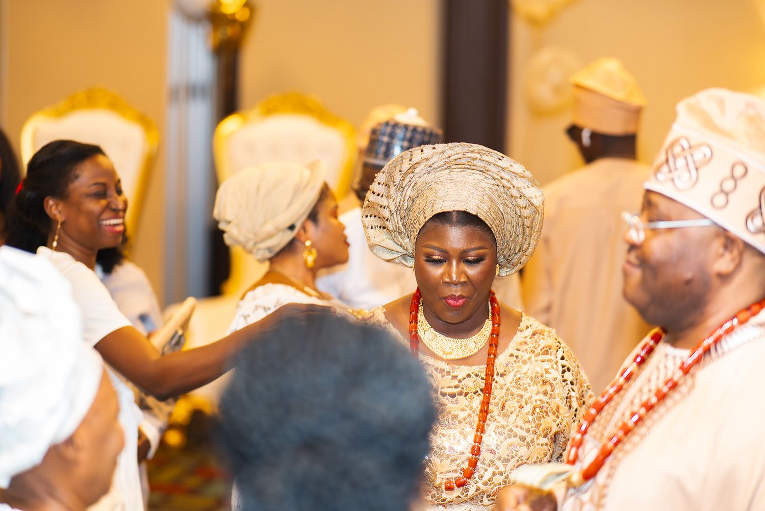 Wedding celebration featuring traditional Nigerian attire and festive dancing in a warmly lit venue.