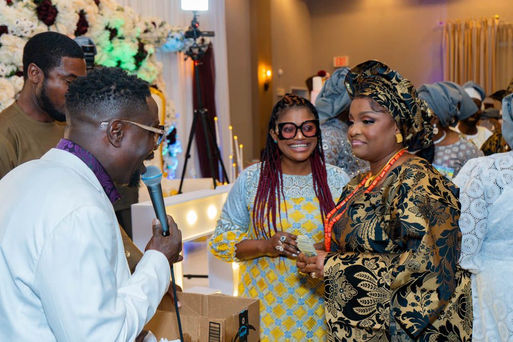 Wedding reception candid moments showing guests mingling in traditional African clothing.