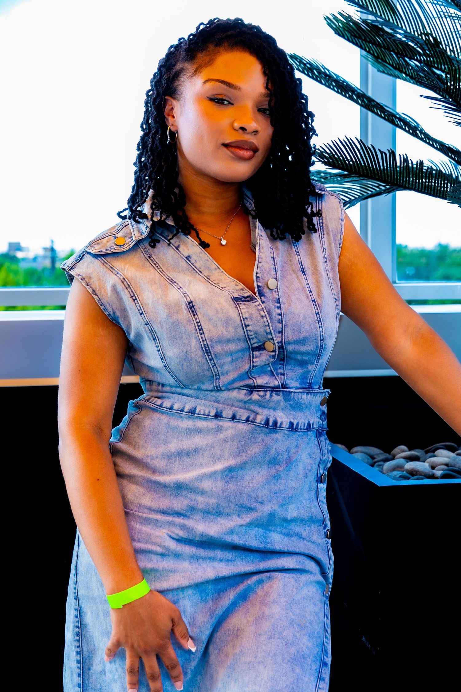 Person wearing light denim dress striking casual poses outdoors.