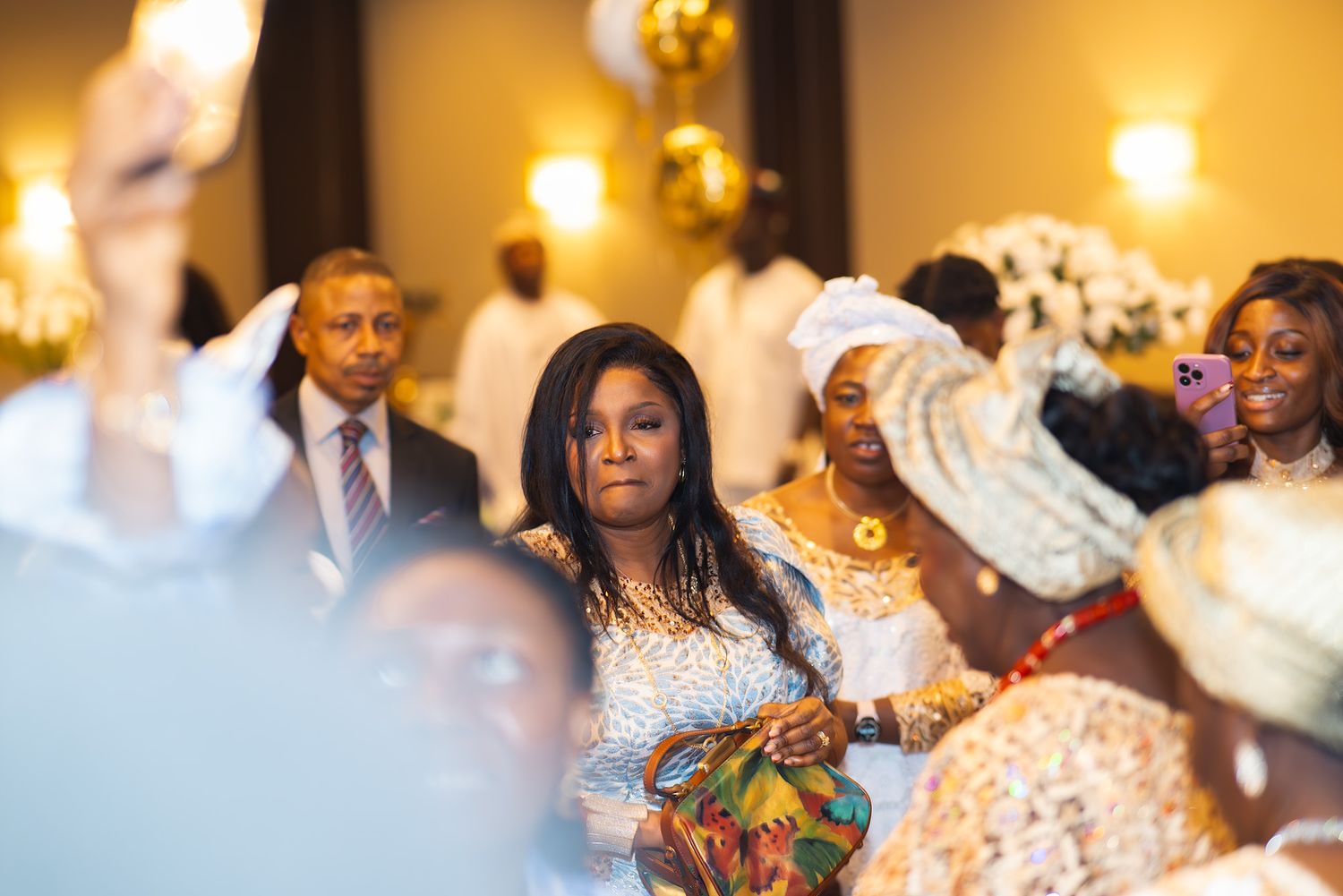 Guests celebrate at a lively wedding reception with colorful decor and warm lighting.