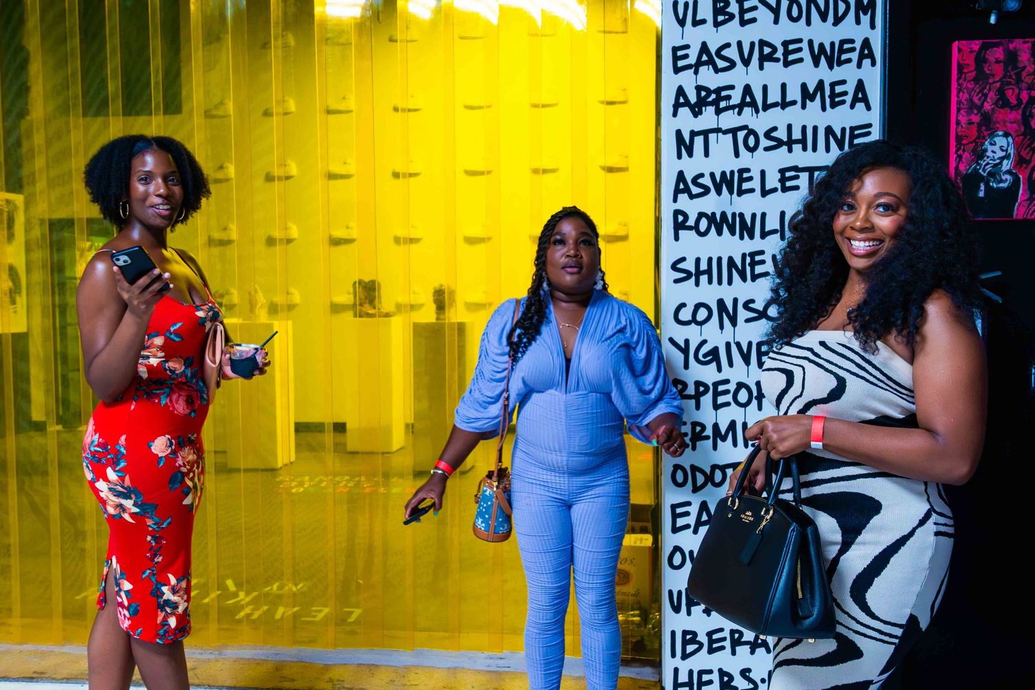 Yellow-lit gallery space with text art and multiple interactive installations.