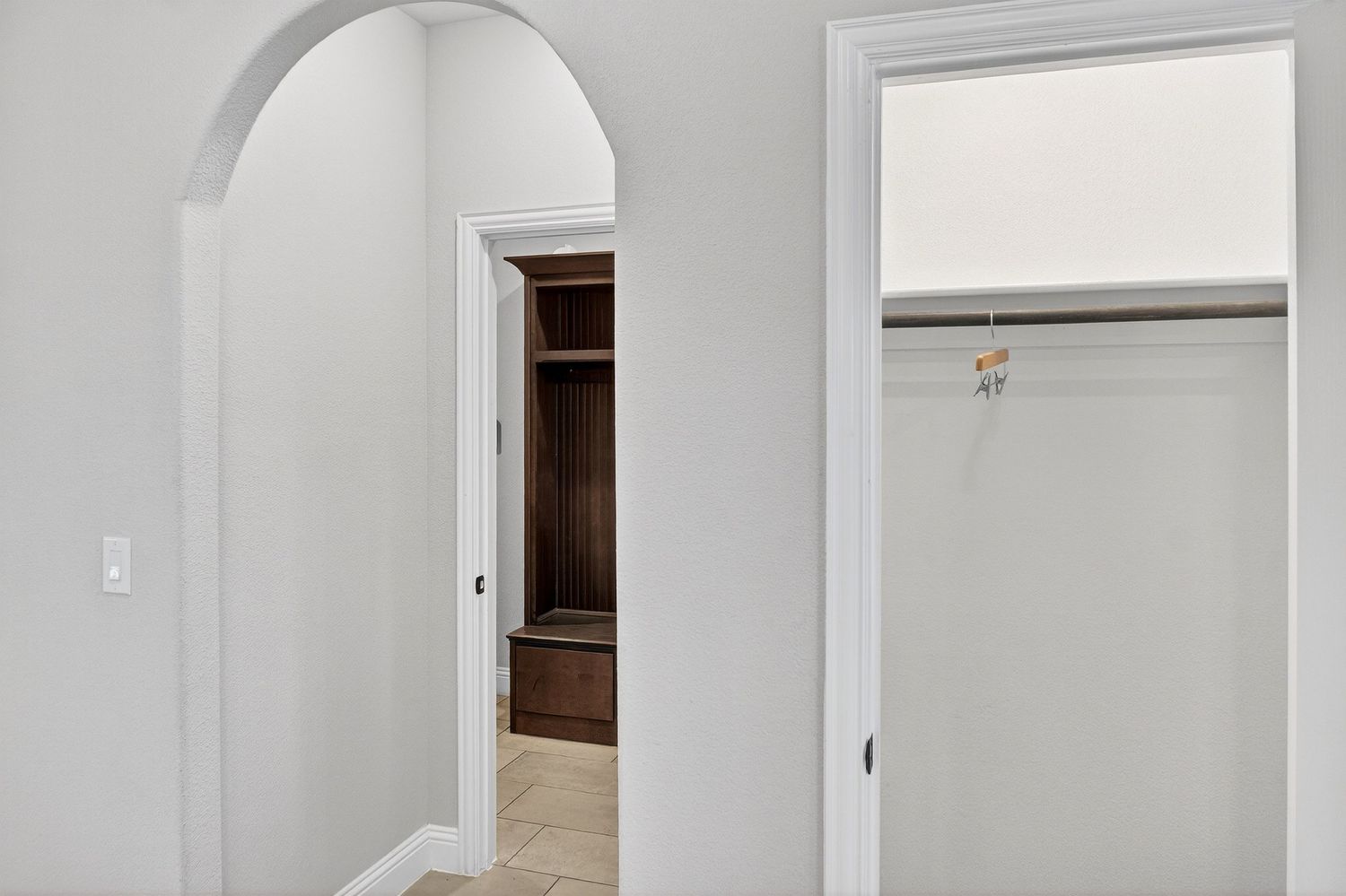 Clean white interior hallway with arched doorways and modern architectural details.