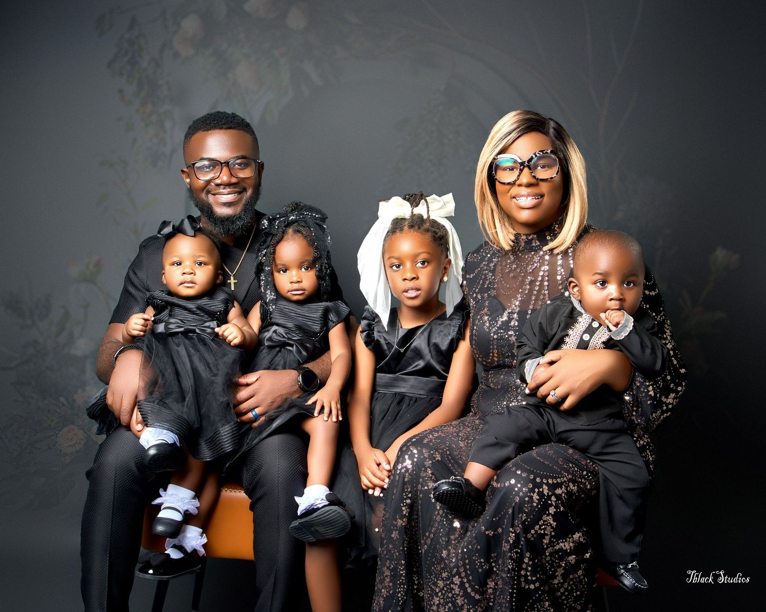 Professional family photo series with everyone dressed in elegant black and sparkly attire.