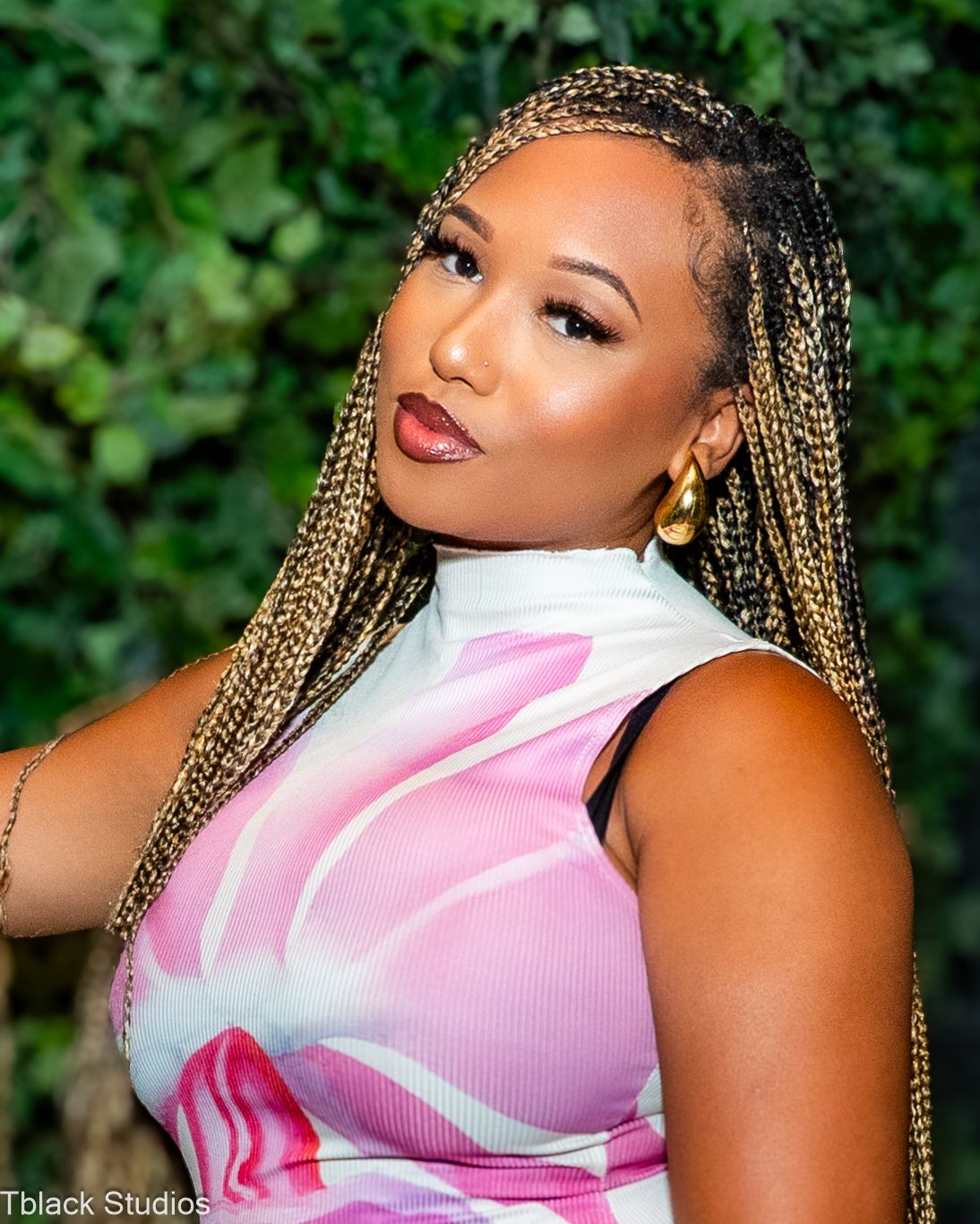 Summer fashion shoot featuring pink and white sleeveless top against natural green background.