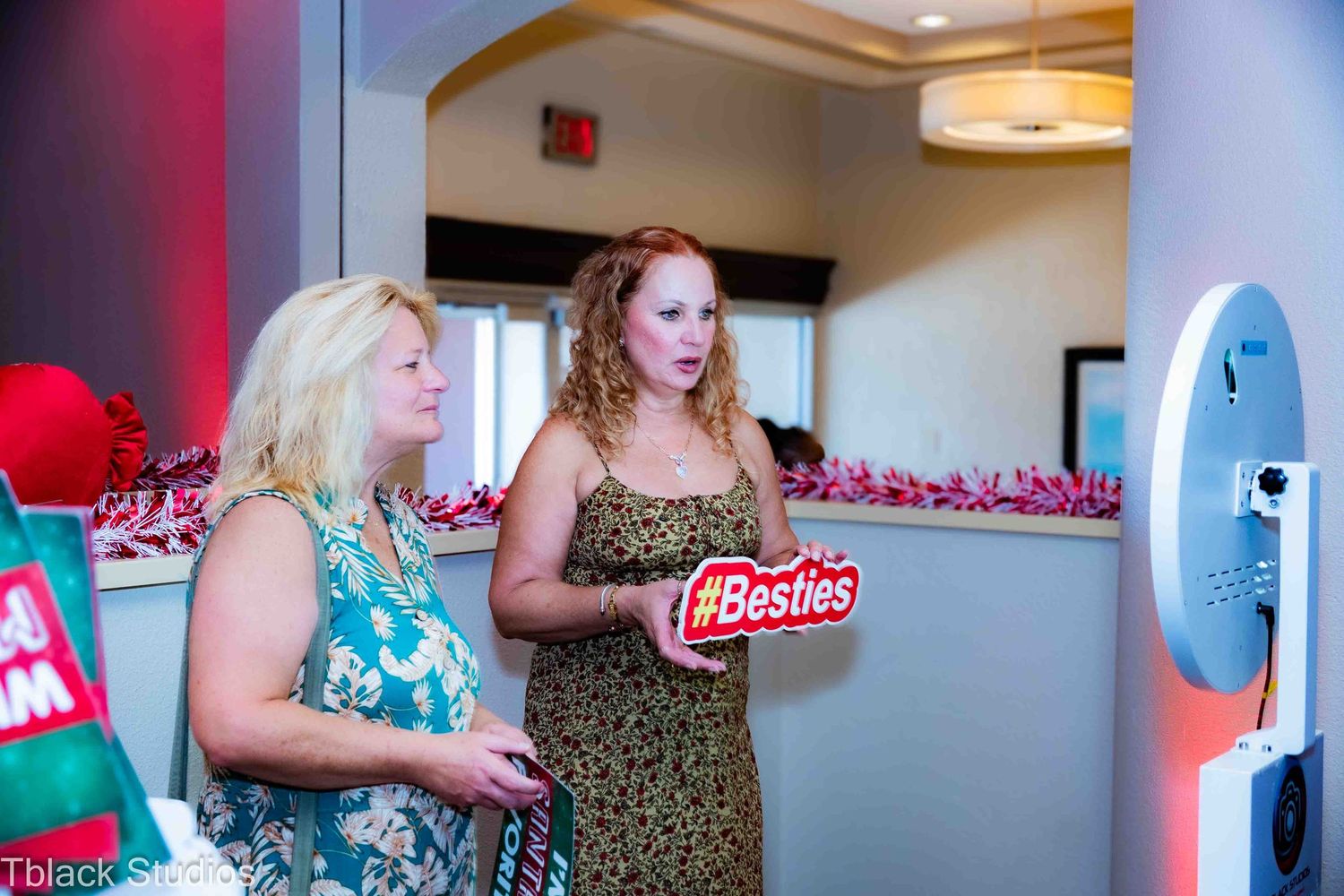 Group gathering in an indoor event space with photo booth setup.