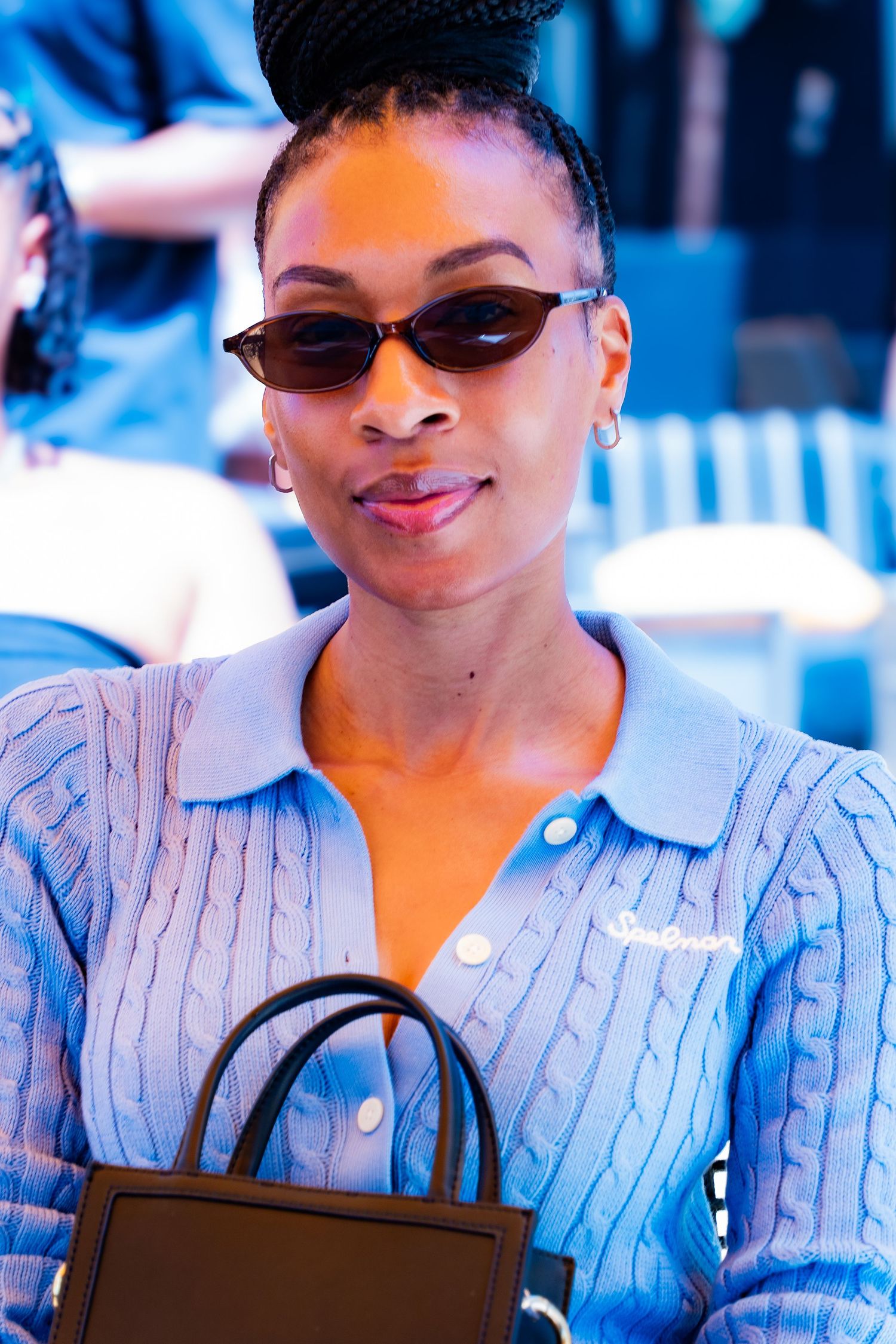 Fashion detail shots of a blue striped button-up shirt with black sunglasses and handbag.