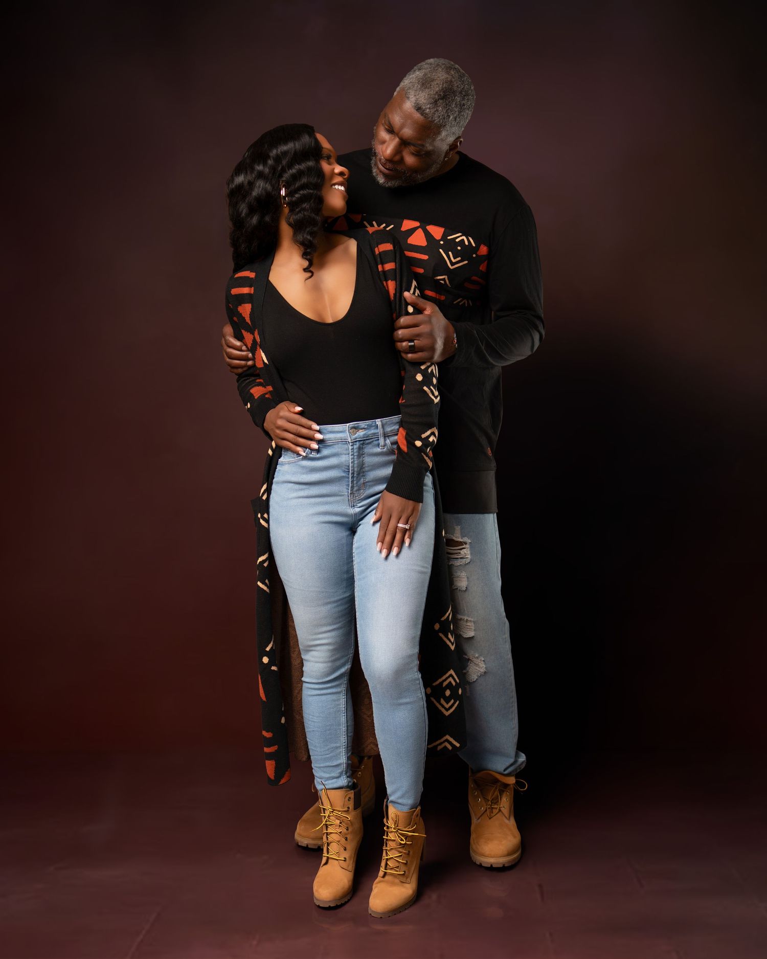Urban fashion photography featuring denim and boots against dark studio background.
