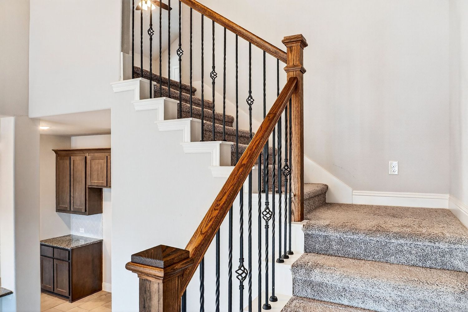 Elegant staircase design featuring wooden steps, white risers, and black metal spindles.