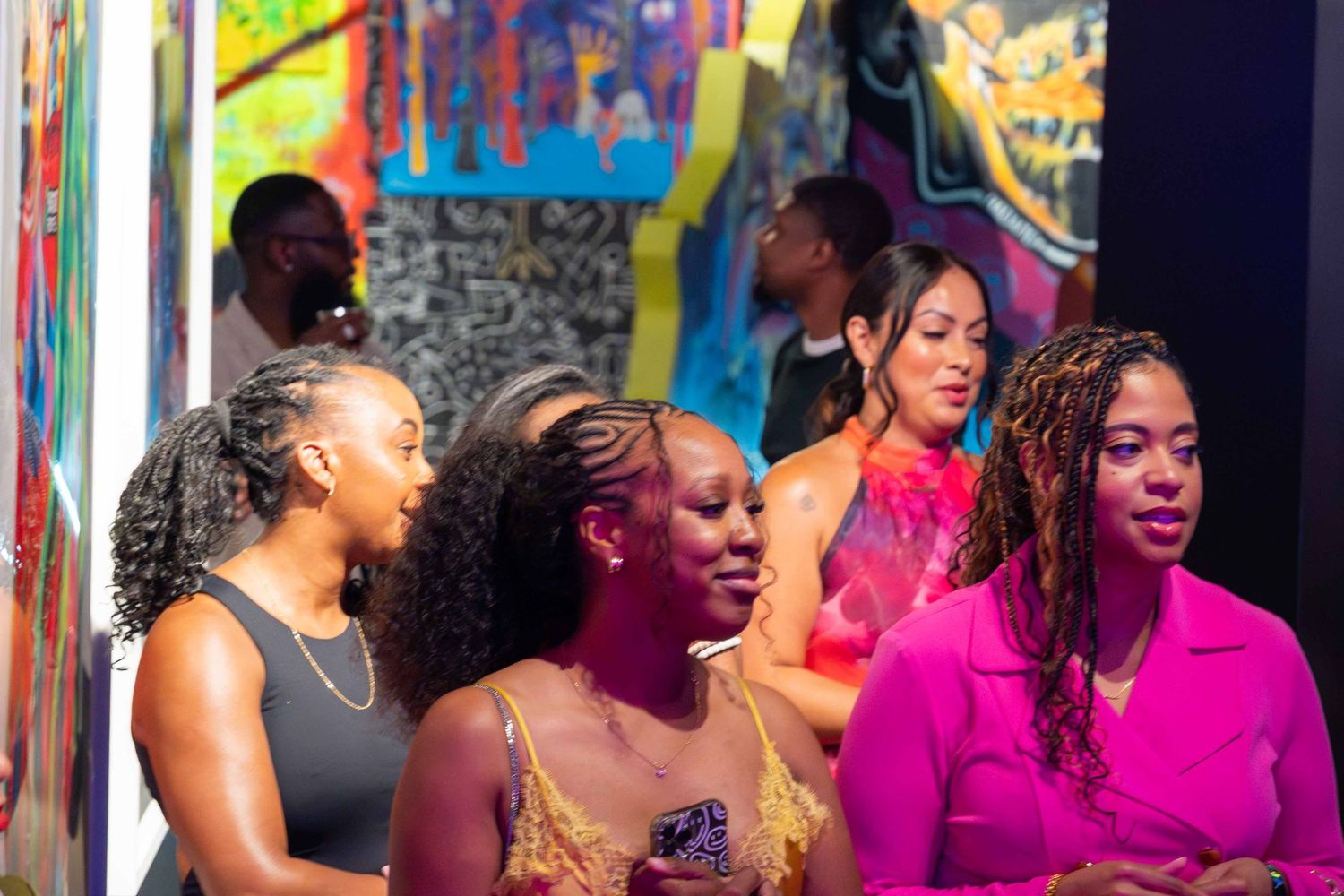 Group enjoying a lively celebration under bright magenta lighting.