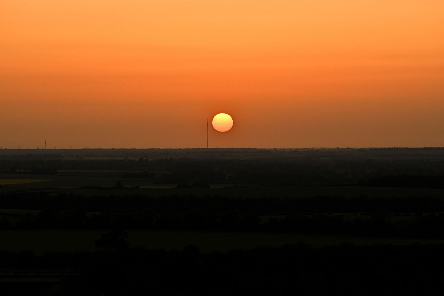 The sun prepares to set over the horizon at Therfield Heath as landscape golden hour photography are available as wall art prints.
