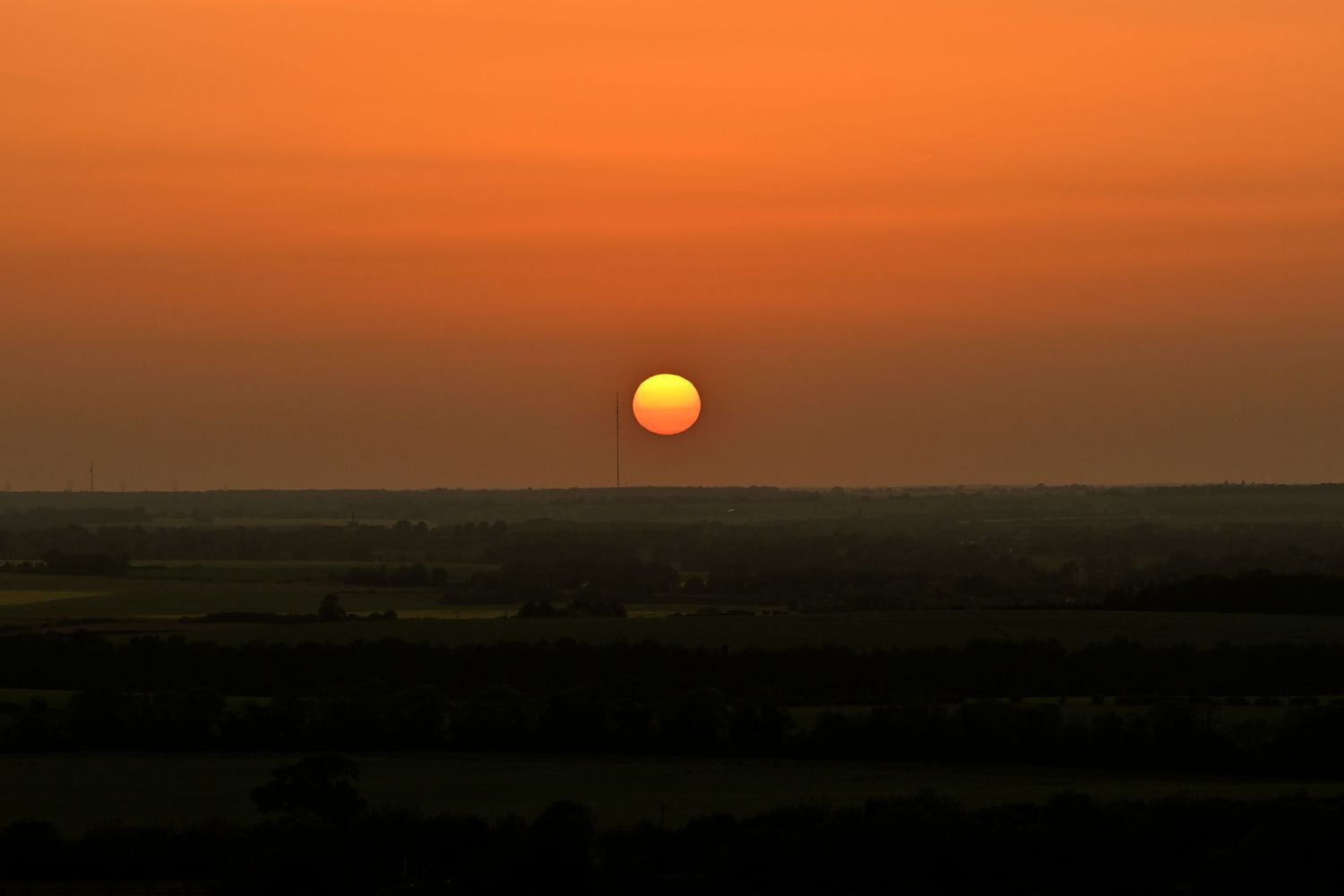 The sun prepares to set over the horizon at Therfield Heath as landscape golden hour photography are available as wall art prints.