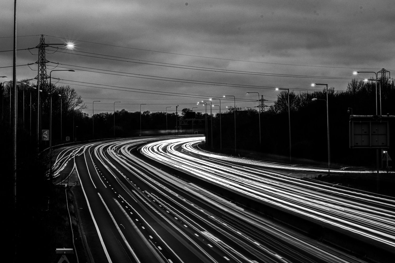 Vehicles passing M25 near Potters Bar as black & white light trails photography available as fine art wall prints.