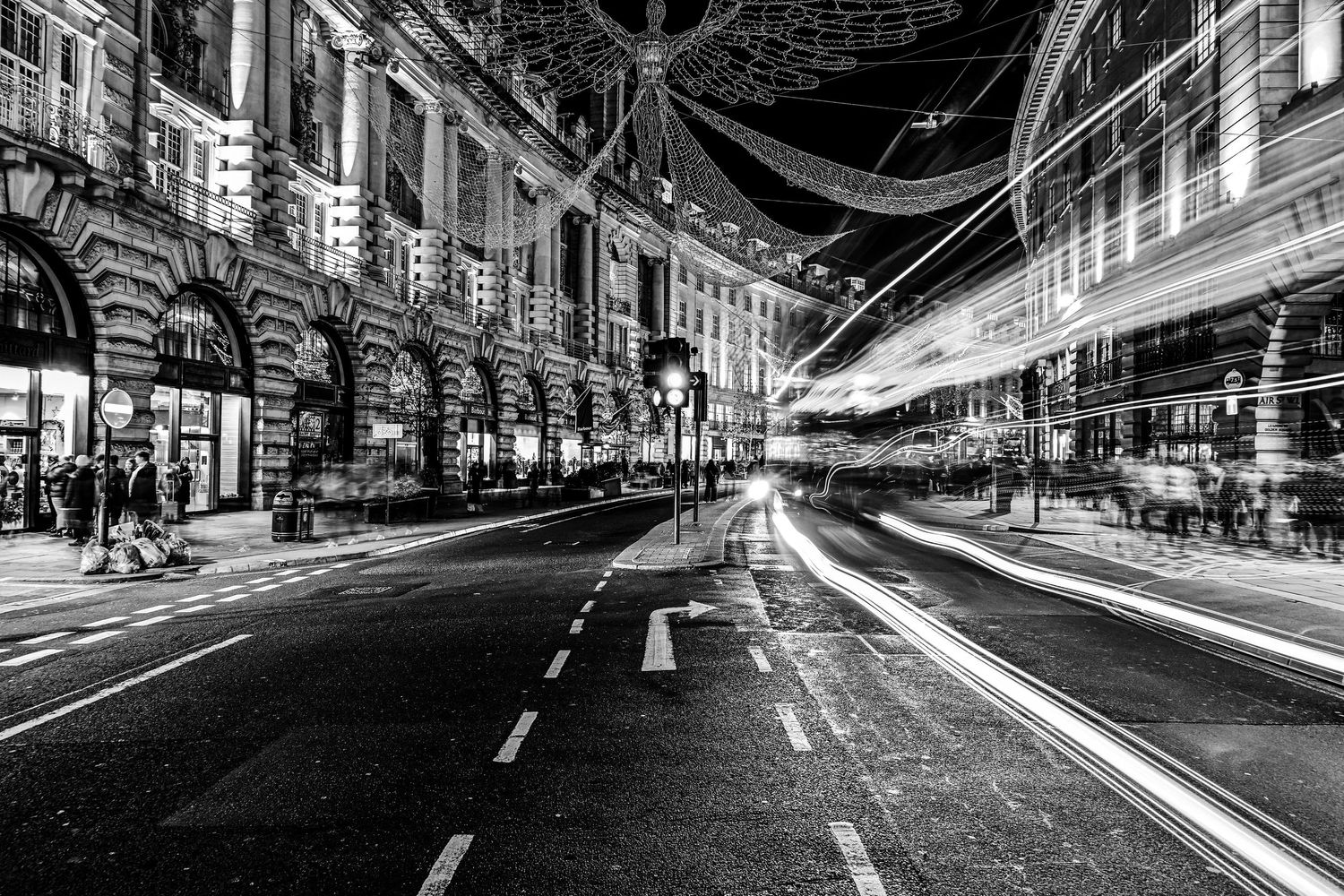 Vehicles passes Piccadilly Circus as black & white light trails photography available as fine art wall prints.