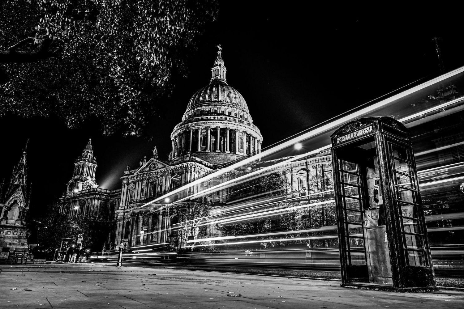 A bus approaches St Pauls Cathedral as black & white light trails photography available as fine art wall prints.