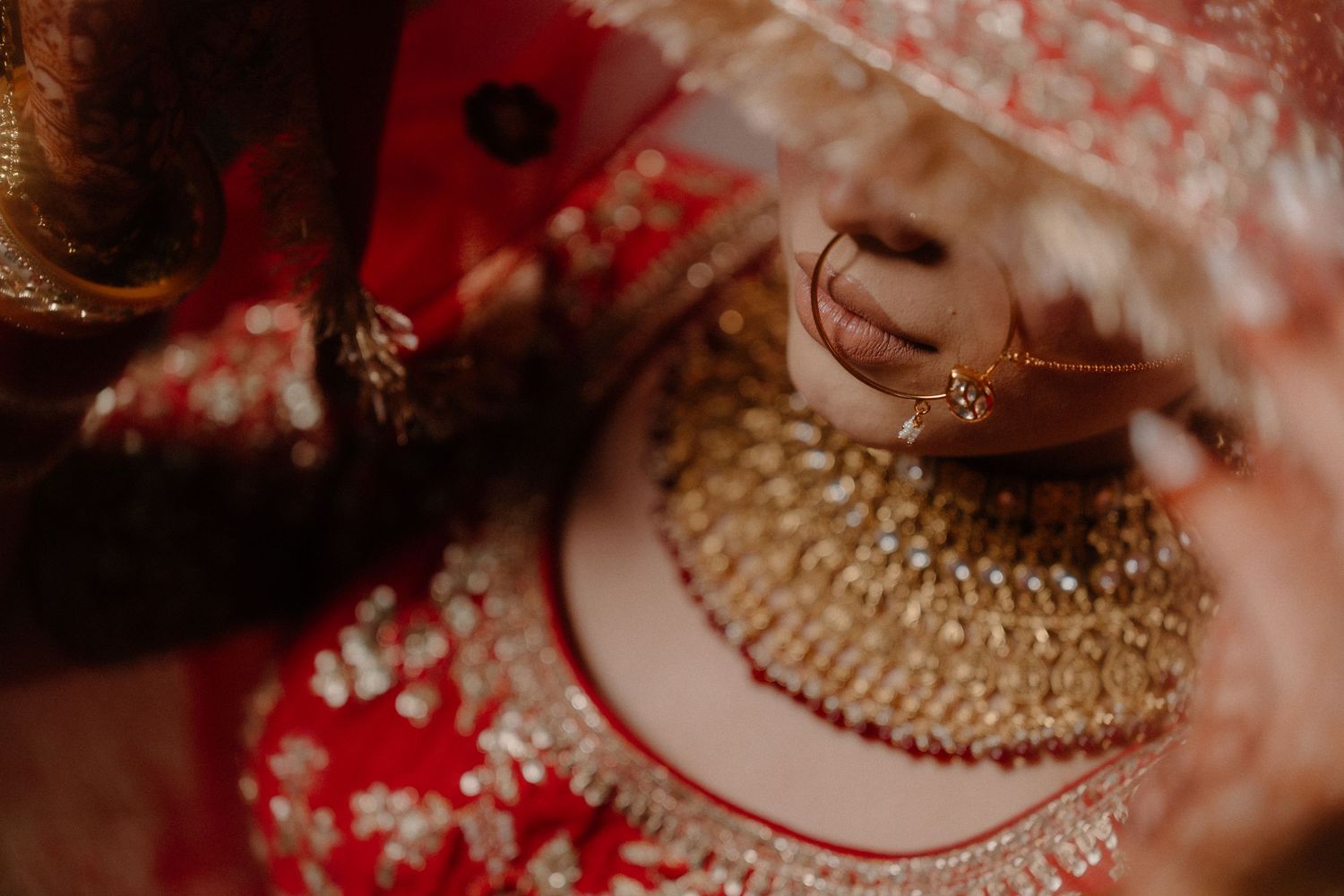 Traditional Indian wedding jewelry and accessories in rich red and gold colors arranged for a bridal photoshoot.
