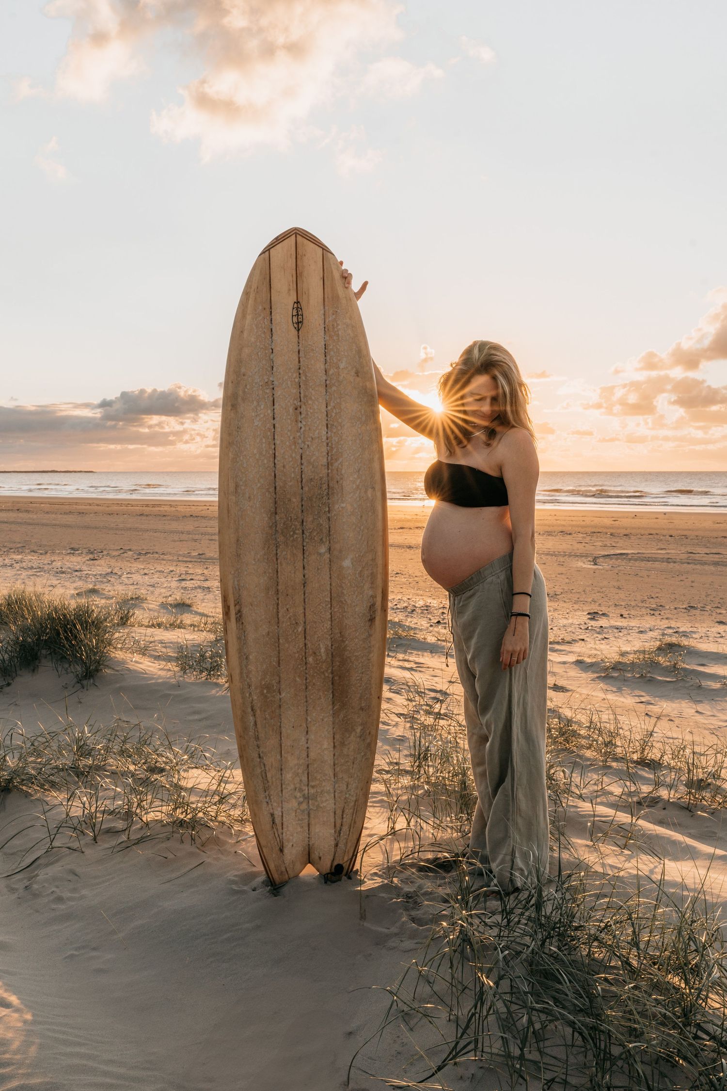 Pregnant surfer girl during maternity shoot